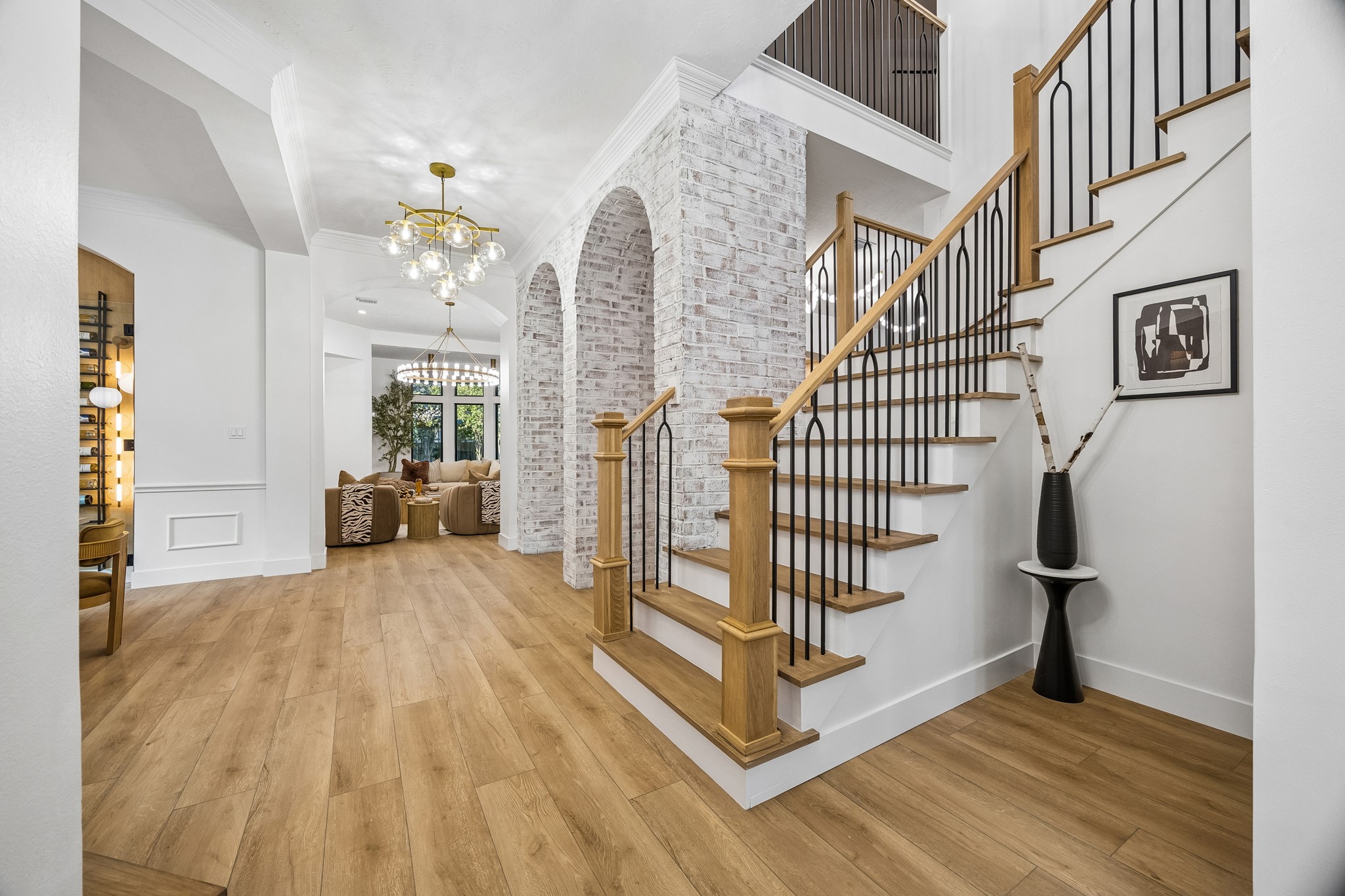 Wide open foyer with a peak at the stone arches sets the tone for the home