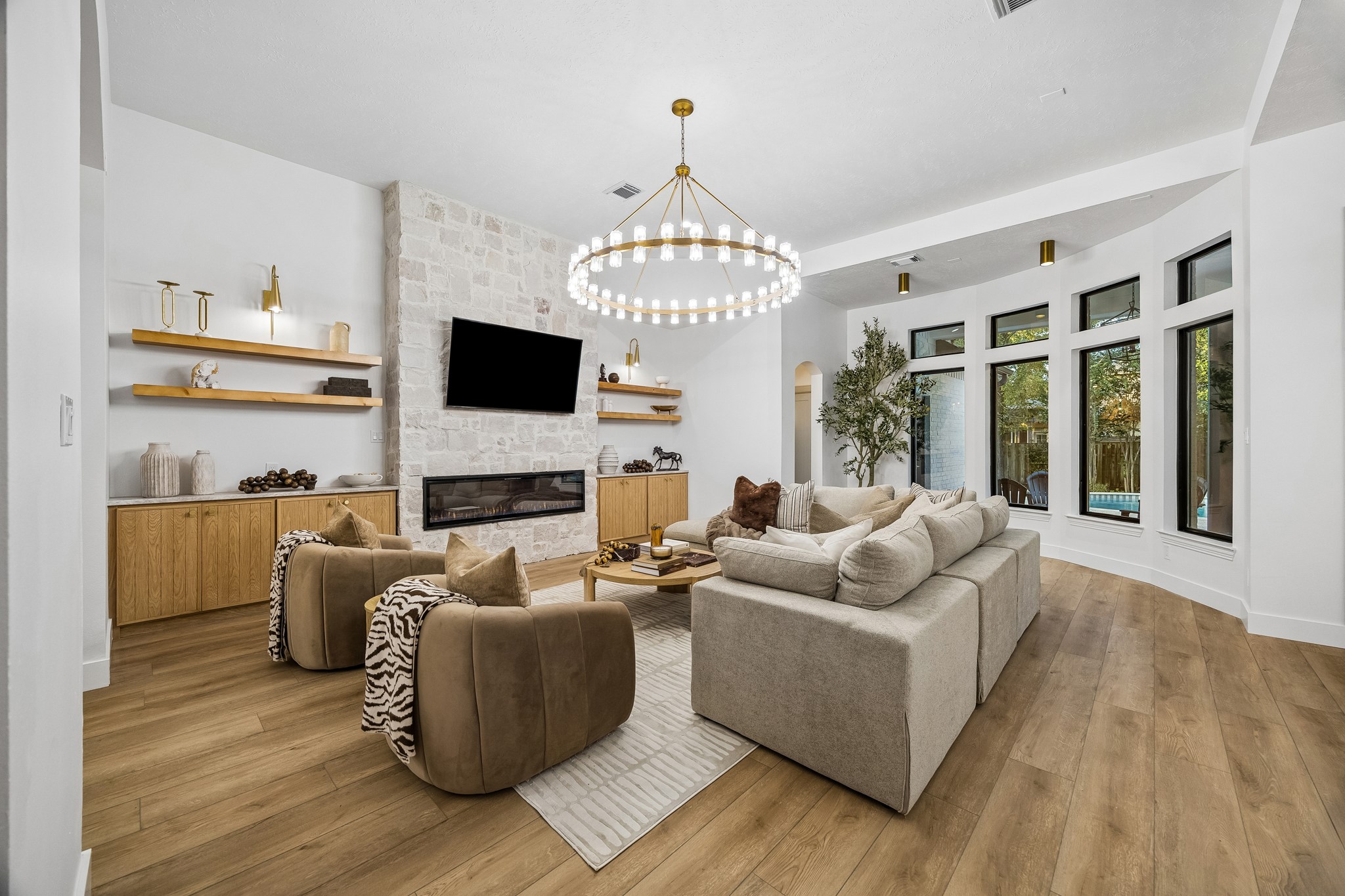 The living room features a stunning chandelier, custom cabinetry and shelving