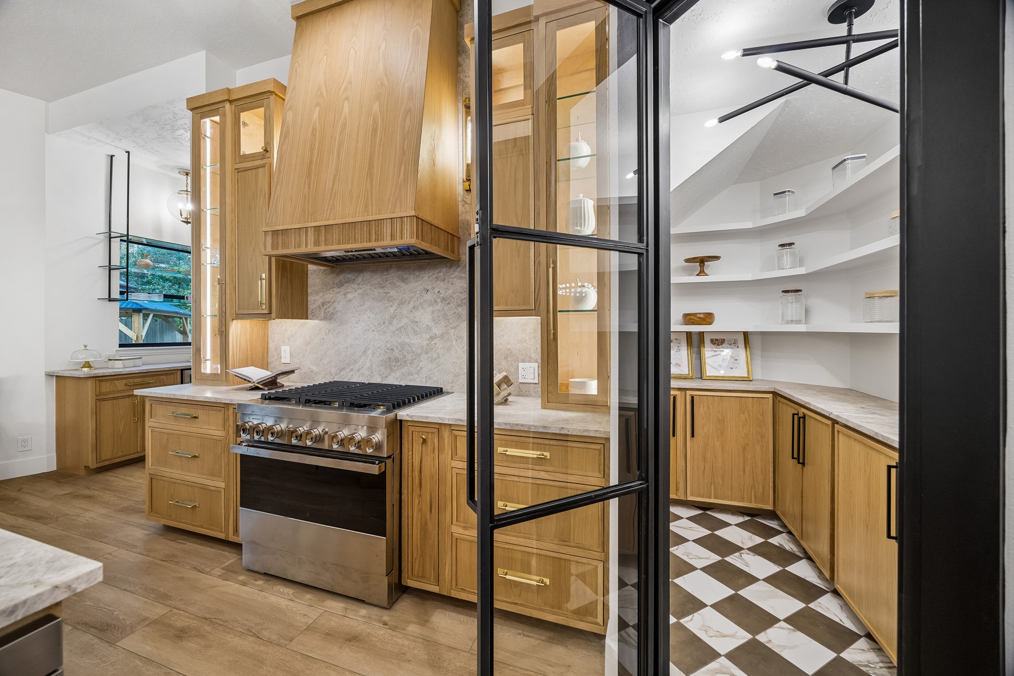 A custom walk-in pantry with cabinets and floating shelving