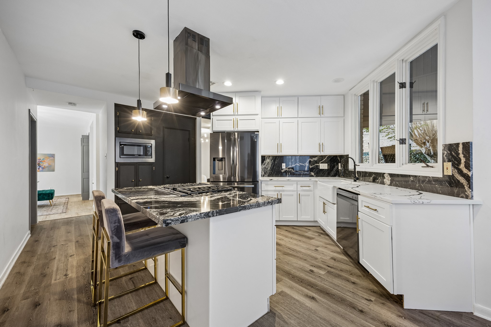 Island kitchen with gas cooktop and venta hood.