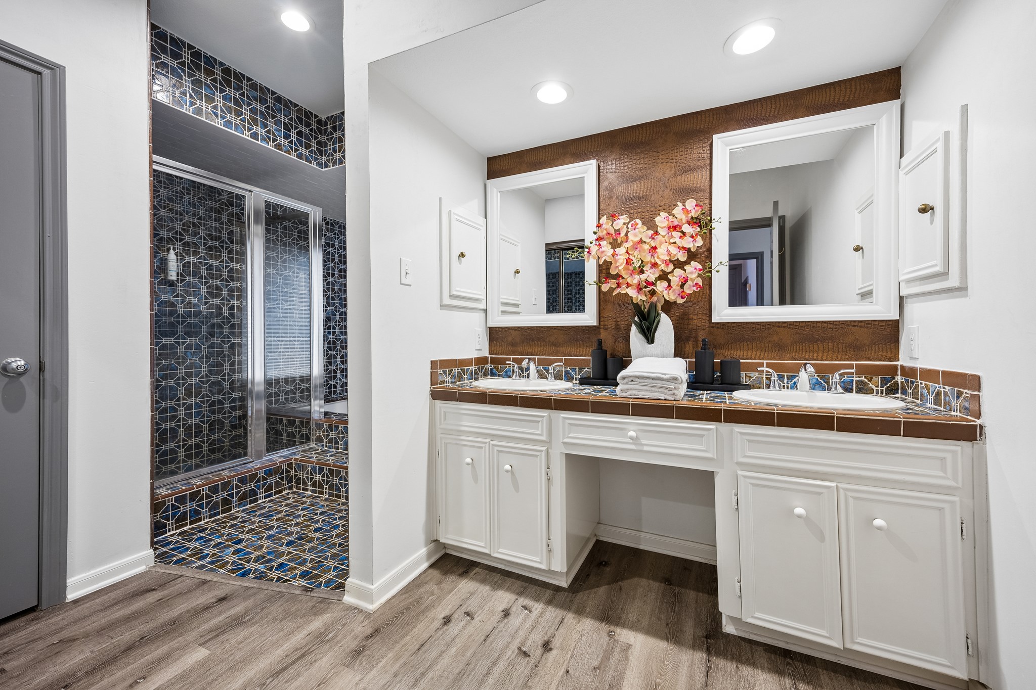 Primary Bathroom featuring a dual vanity, a soaking tub, and a separate walk-in shower.