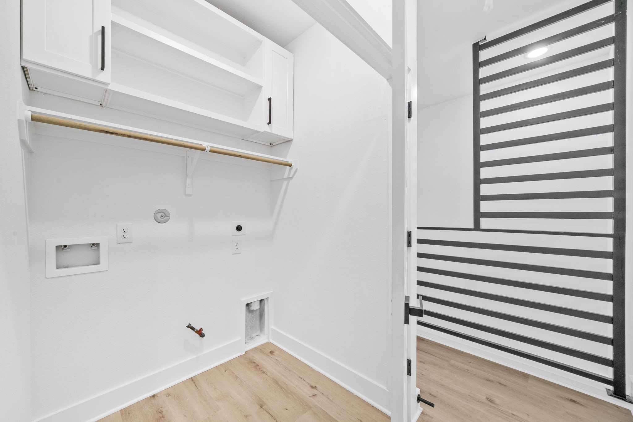 Unit C laundry closet with built in cabinets and shelves.