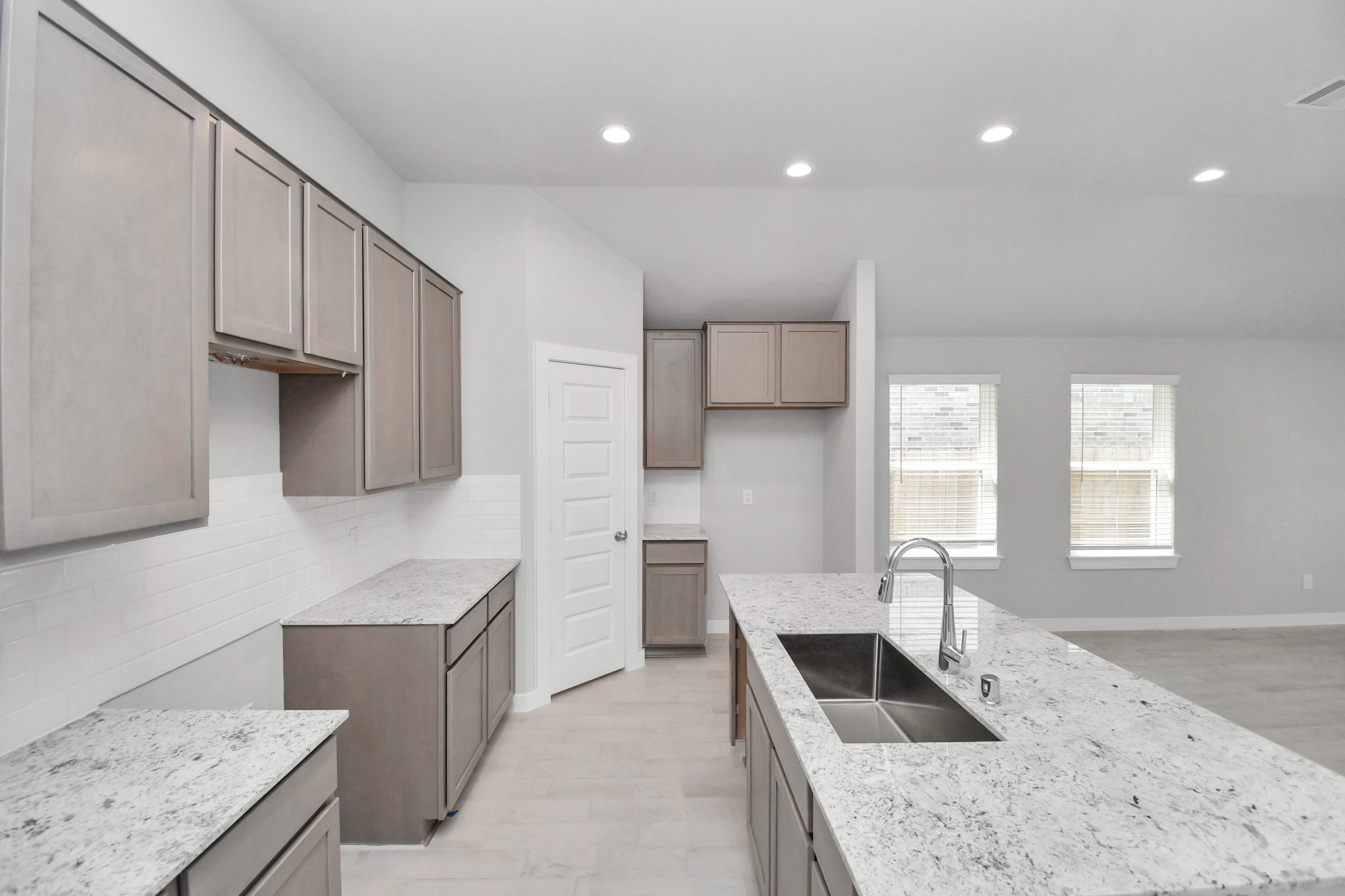 This kitchen is by far any chefs dream! This spacious kitchen features high ceilings, stained wood cabinets, granite countertop, SS appliances, modern tile backsplash, recessed lighting, extended counter space, granite kitchen island with double sink, and space for breakfast bar, and a walk-in pantry all overlooking your huge family room. Sample photo of completed home with similar floor plan. Actual colors and selections may vary.