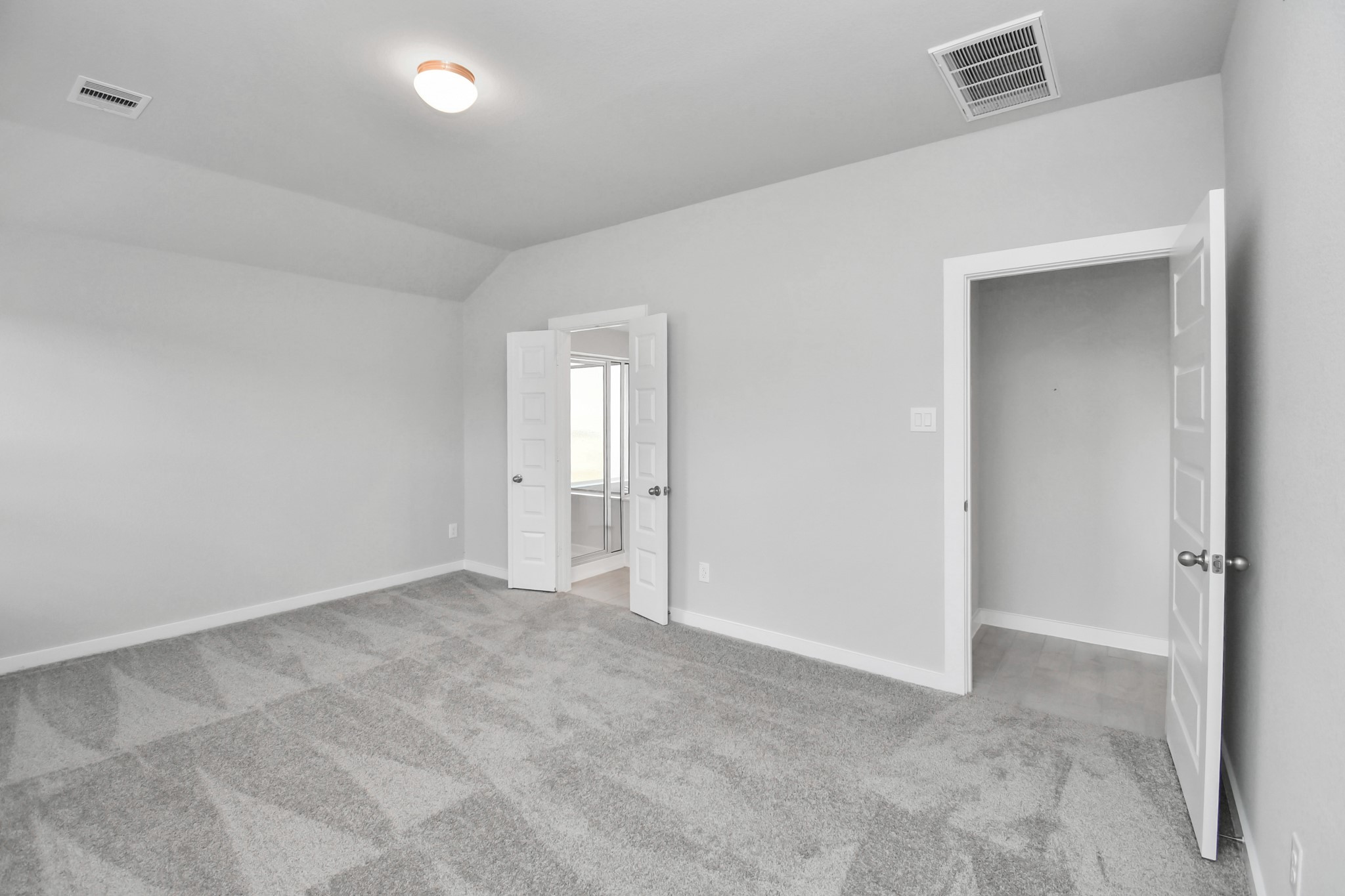 Escape and relax in the exquisite primary suite, a haven to unwind after a long day. The spacious room, boasts plush carpeting, soothing paint tones, high ceilings, and expansive windows adorned with privacy blinds. Sample photo of completed home with similar floor plan. Actual colors and selections may vary.