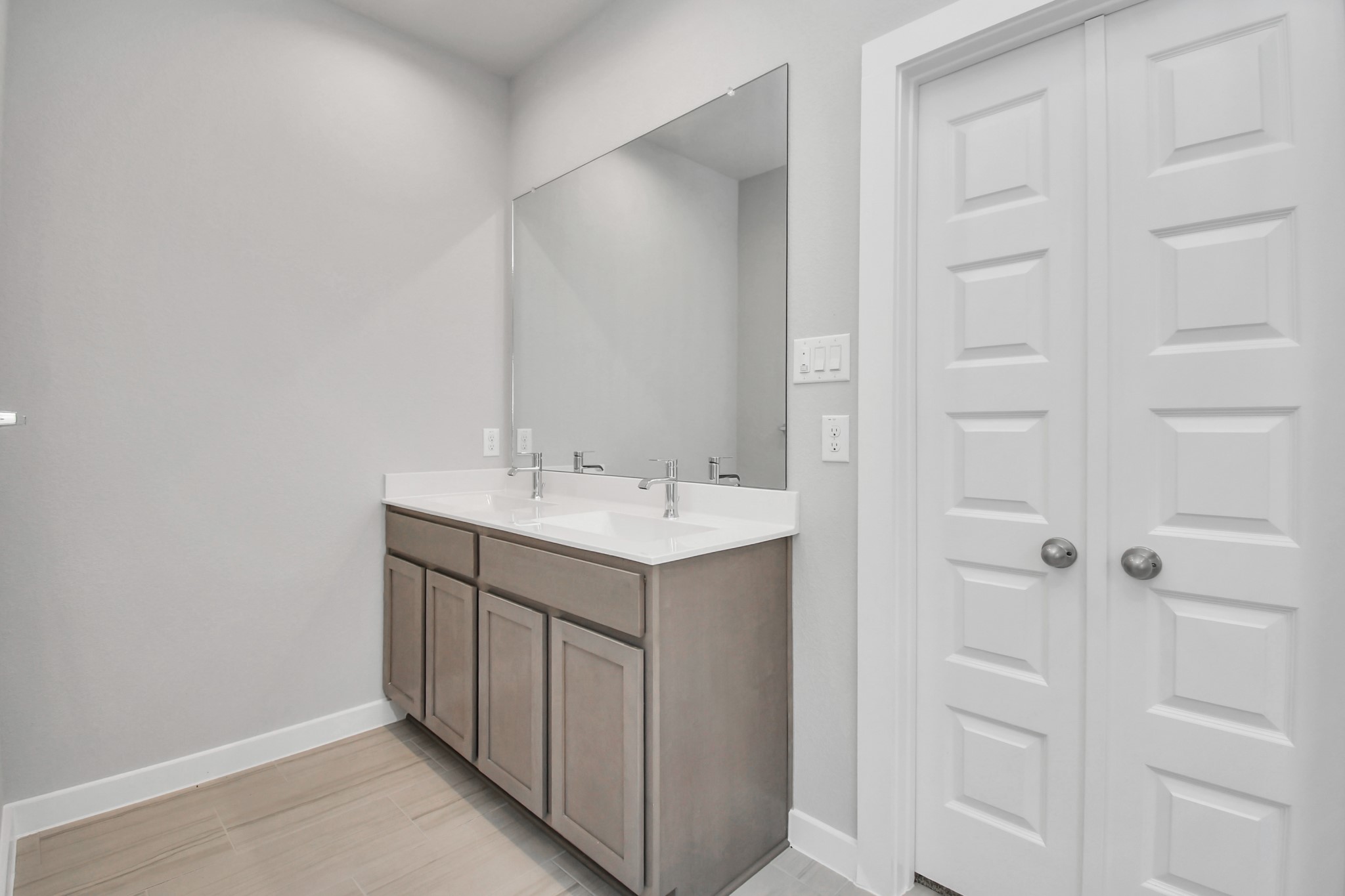 Elevate your daily routine at the elegant vanity, now equipped with double sinks, light countertops, modern hardware, and beautiful recessed lights. Sample photo of completed home with similar floor plan. Actual colors and selections may vary.