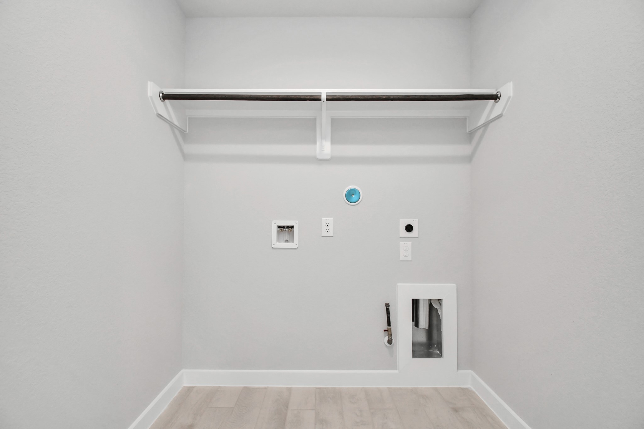 A perfect blend of functionality and comfort. Capture the essence of easy living with a first-floor laundry room, thoughtfully equipped with shelving for effortless organization. Both electric and gas connections available. Sample photo of completed home with similar floor plan. Actual colors and selections may vary.