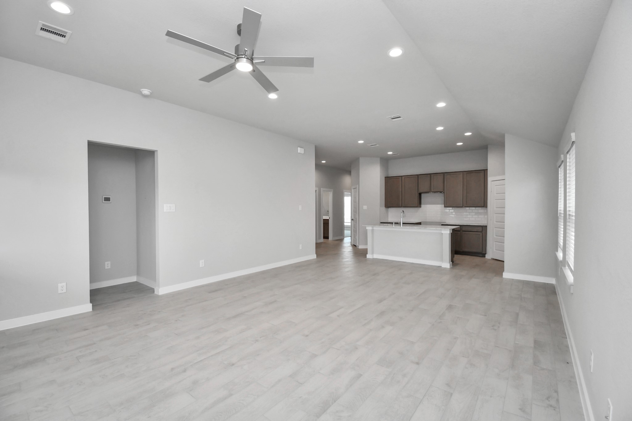 Family room flooded with natural light through the expansive windows.  The premium tile flooring adds a touch of luxury to the space, creating the perfect setting for relaxing moments and cherished gatherings with loved ones. Sample photo of completed home with similar floor plan. Actual colors and selections may vary.