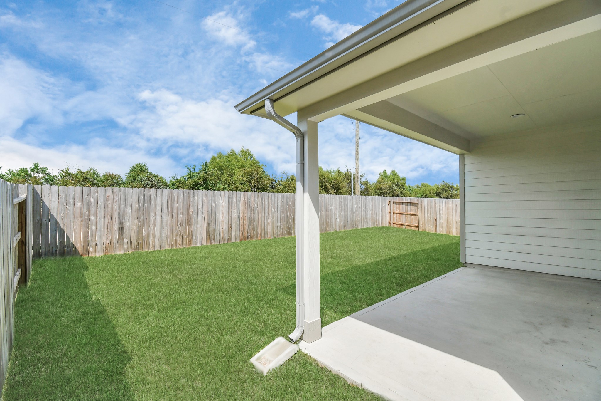 Experience outdoor living at its finest on this expansive covered patio, thoughtfully designed for BBQs and delightful outdoor dining. Sample photo of completed home with similar floor plan. Actual colors and selections may vary.