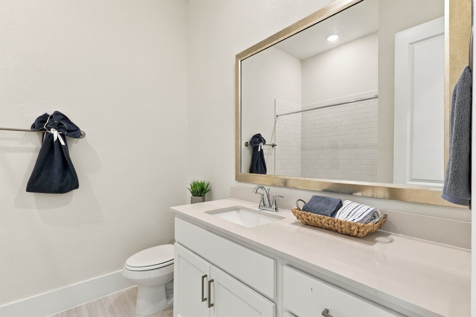 Beautifully Designed with Comfort & Style! This stunning new 1-story home offers the convenience of THREE FULL BATHROOMS on the first floor! This lovely secondary bathroom showcases a spacious vanity with gorgeous quartz countertops, a deep undermount sink, and plenty of cabinet and drawer storage for all your essentials! Notice the beautiful, framed mirror, stylish contemporary fixtures, and elegant neutral finishes that create a bright, fresh, and inviting atmosphere!
