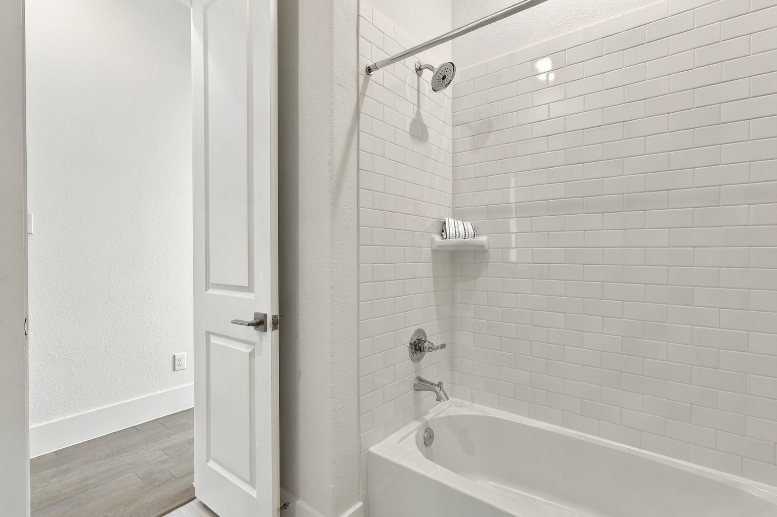 This bathroom has tub and shower combination with stunning chic subway grass tile surroundings!