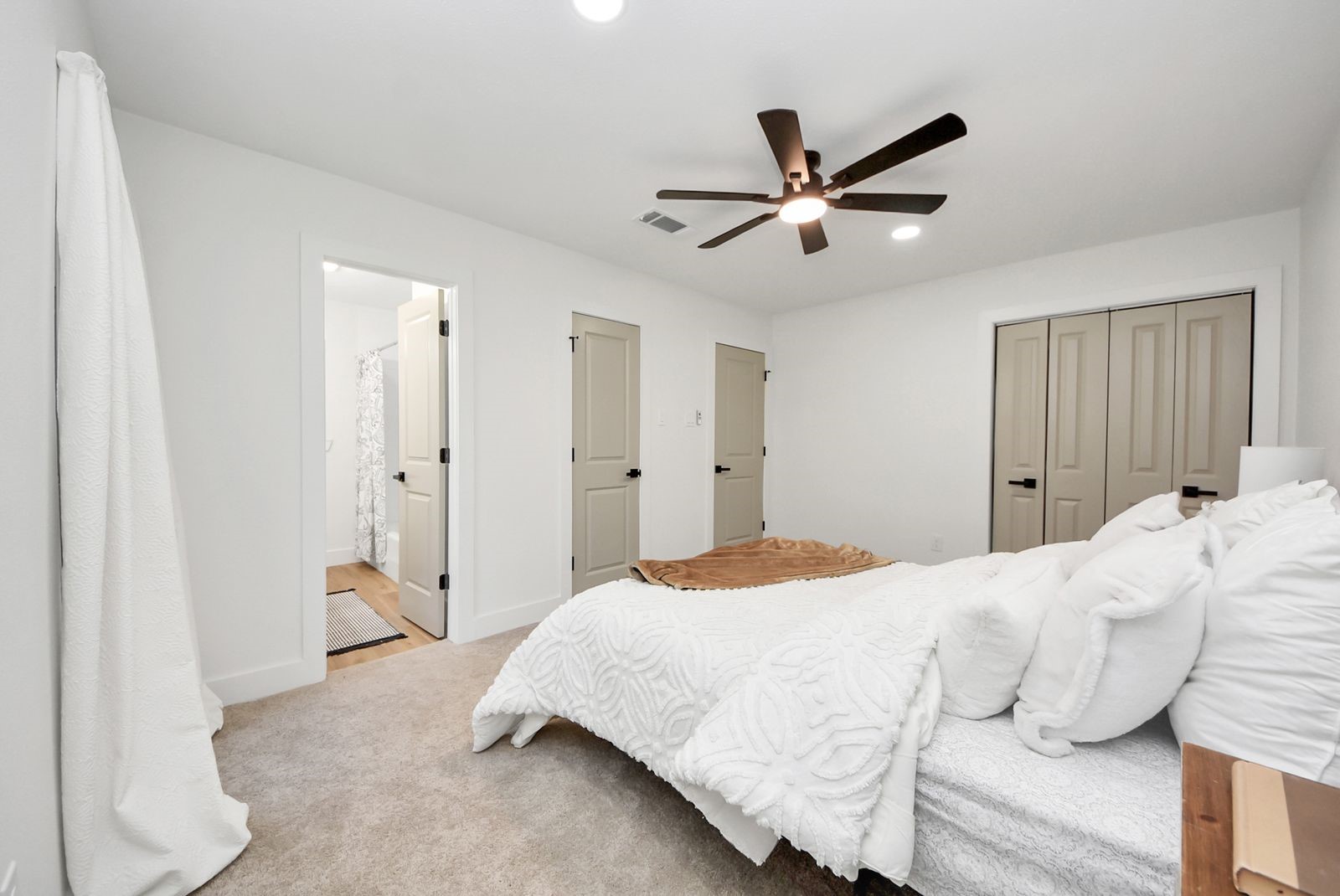 Primary bathroom is located on the far left. 2 of 2 closet door located in between primary bath and bedroom door.