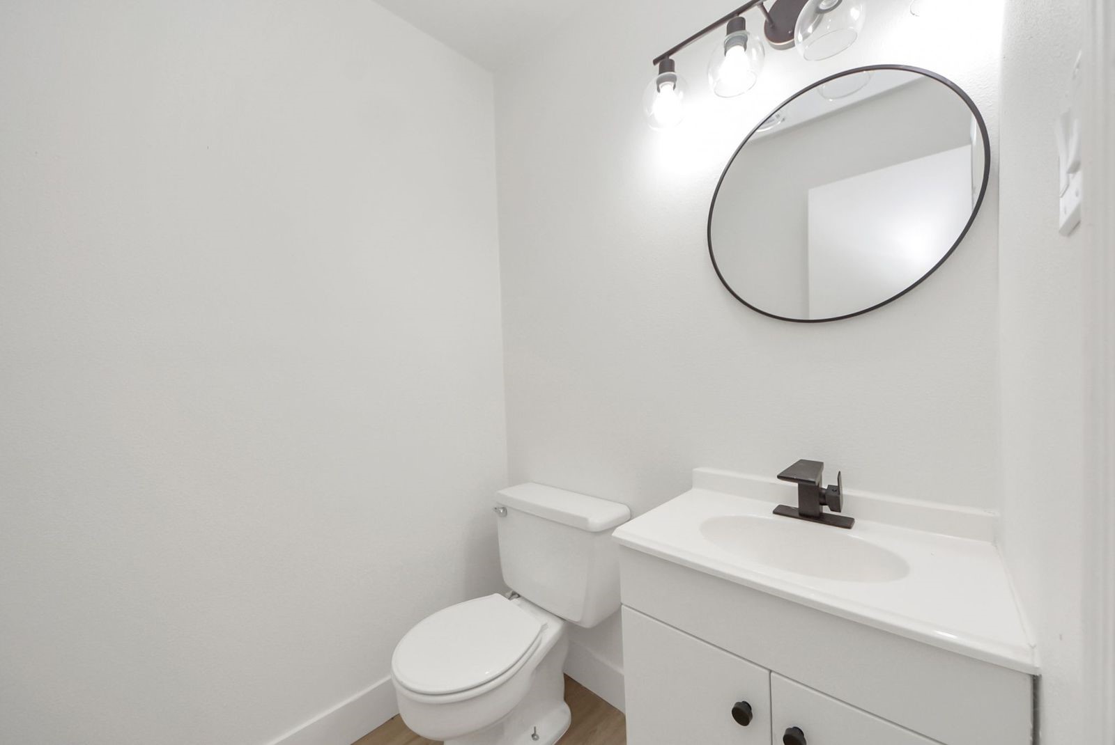 Fully enclosed remodeled half bath located in the garage with a door for privacy.