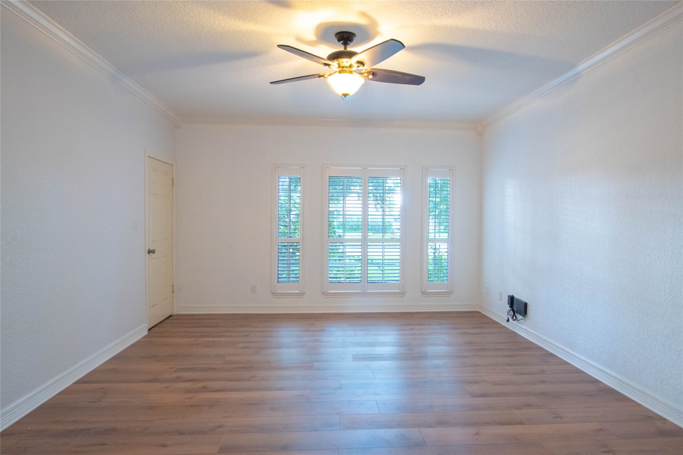 Actual picture of Main bedroom downstairs. with laminated flooring and windows with shutters  overlooking the front yard.