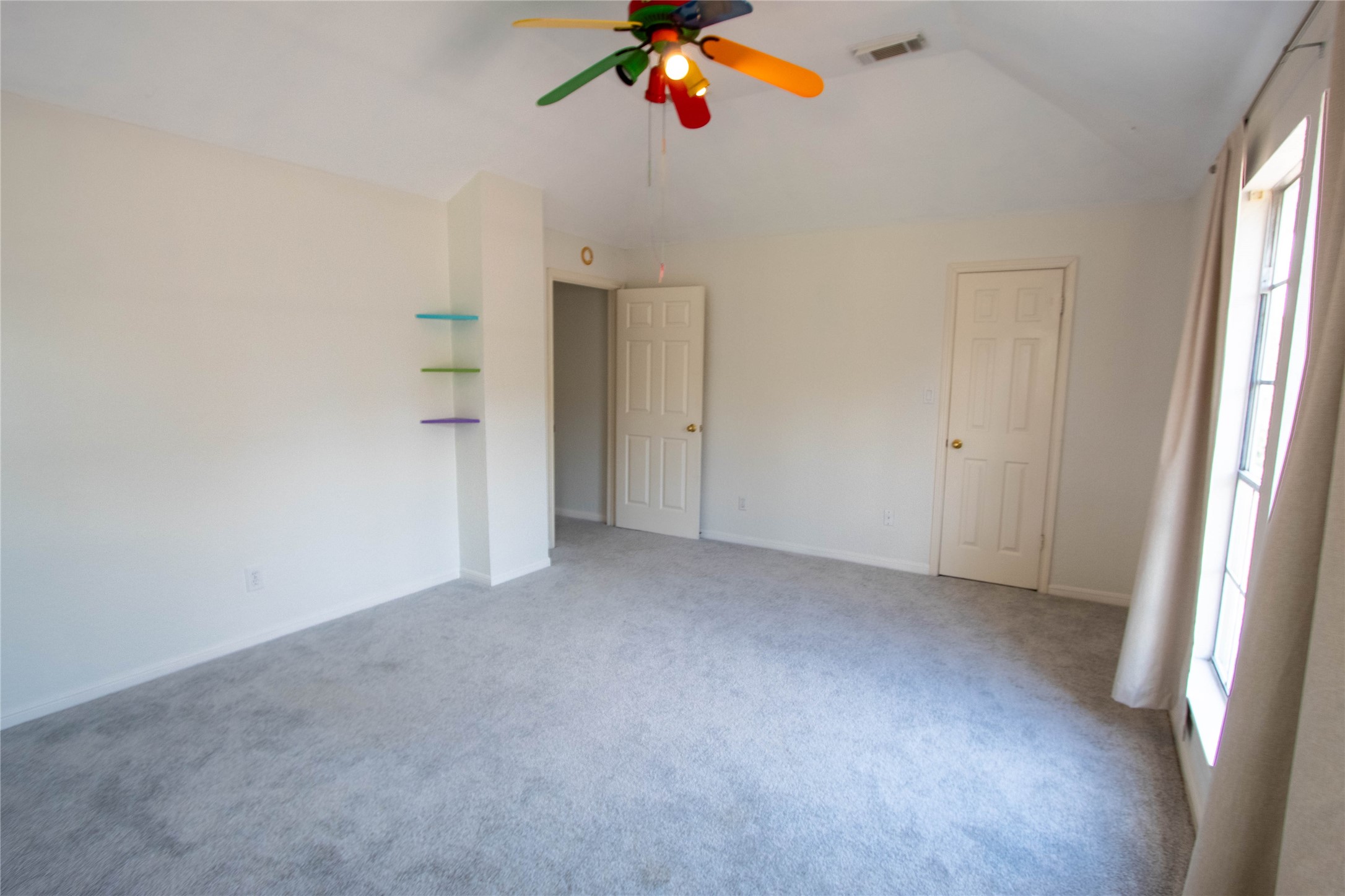 Secondary bedroom overlooking at the driveway and front yard. This is a large room.