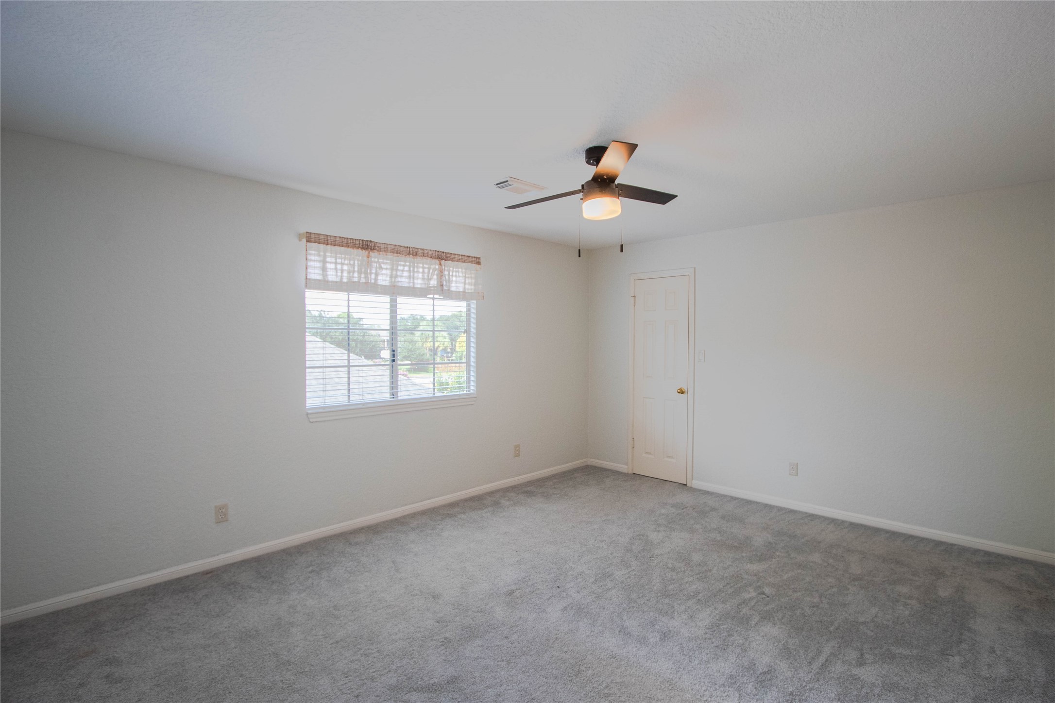 Secondary bedroom, window overlooking the backyard, and walk-in closet.