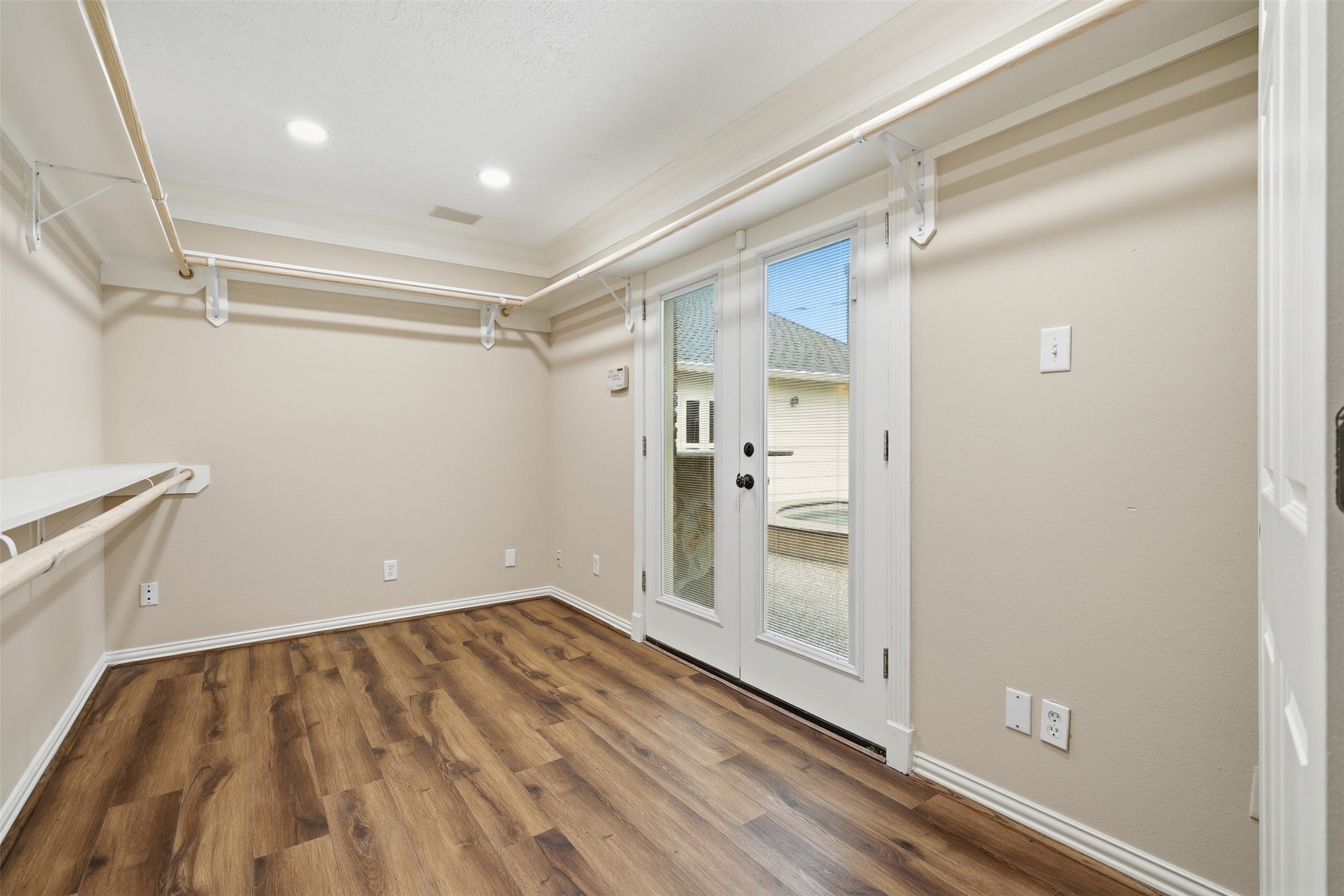 This closet is on the first floor off of the primary bedroom. The double doors open up to the backyard.