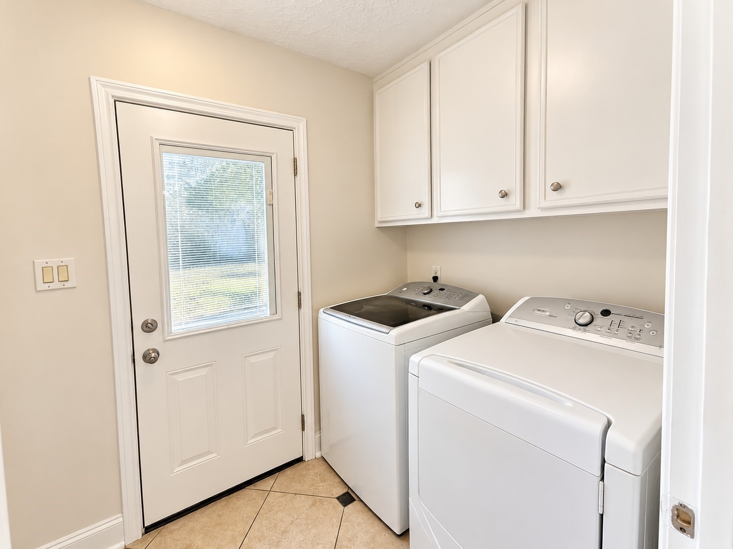 Washer and Dryer room leading out to the covered walkway next to the garage