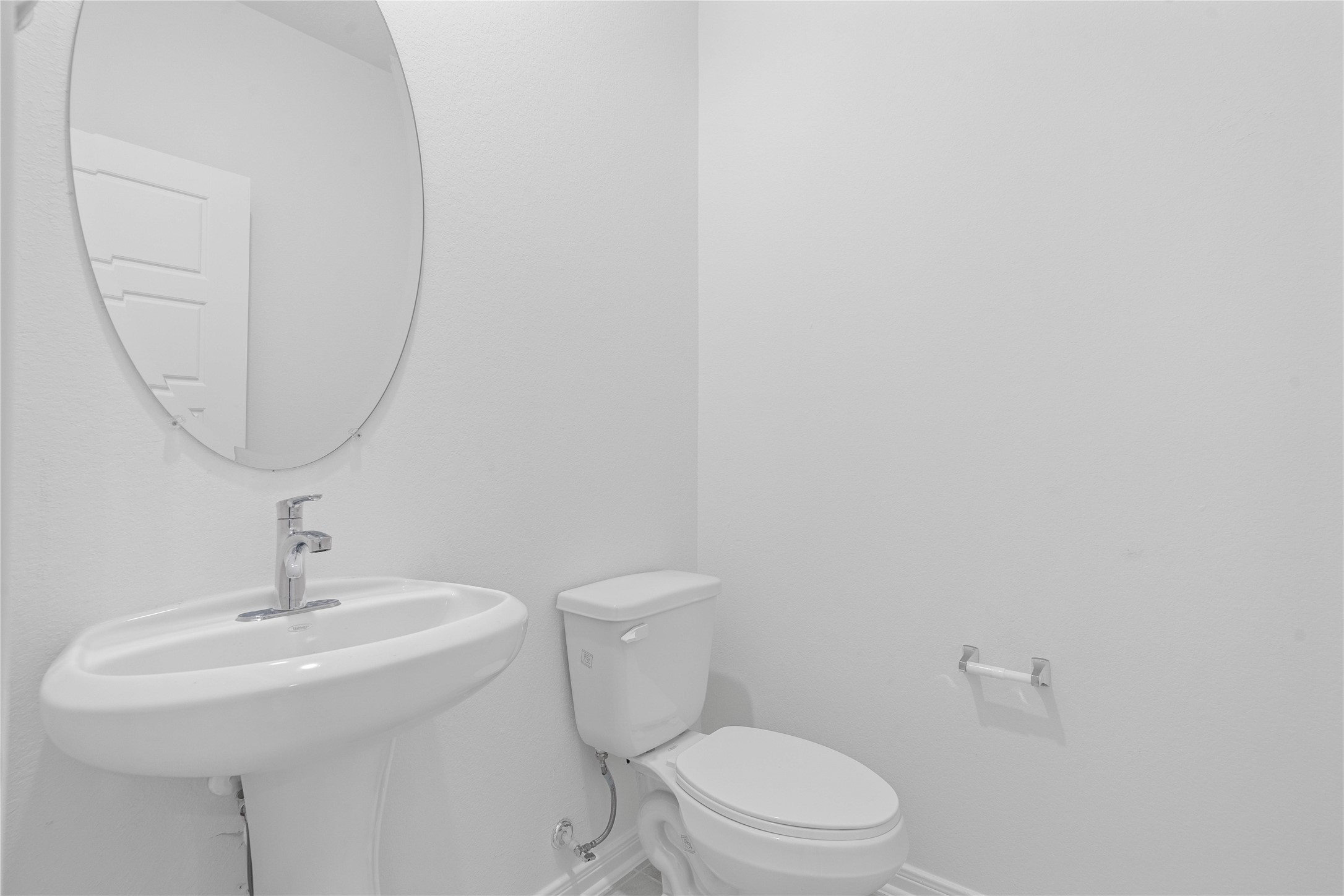 The convenient half bath features clean, neutral finishes and Dune colored tile flooring, creating a polished and practical space for guests.