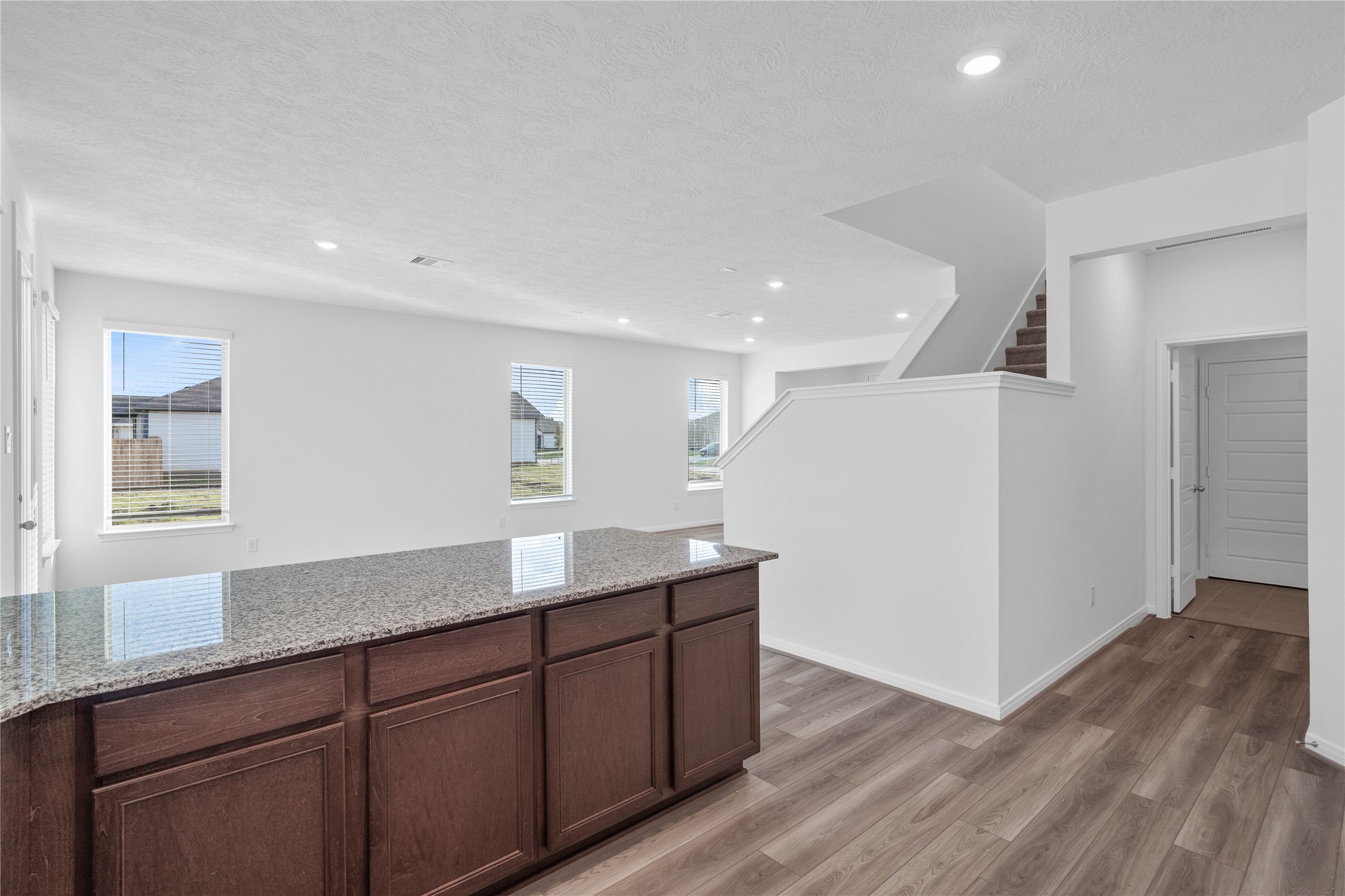 Bring your favorite meals to life in this welcoming kitchen, featuring warm ginger cabinetry, elegant granite countertops, and a modern pearl mosaic backsplash.