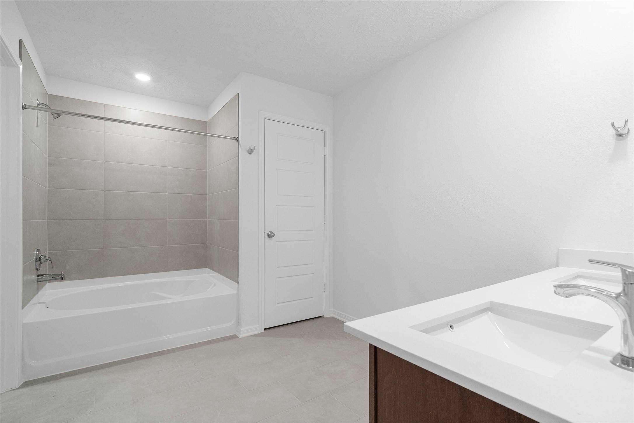 Enjoy a functional primary bathroom with two sinks, a spacious vanity, and a tiled tub and shower combination. Soft neutral finishes bring a cohesive look to this everyday retreat.