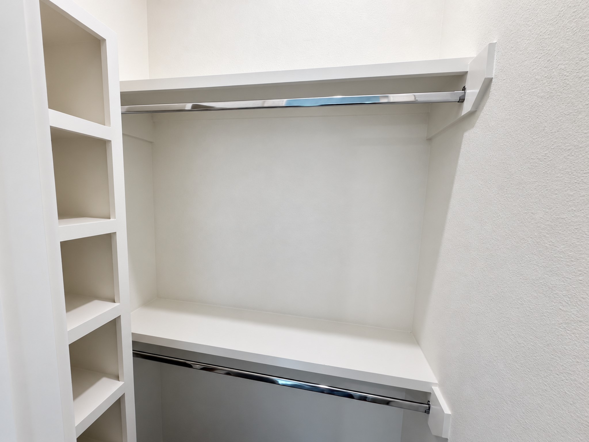 Second-floor closet with built-in shelving and ample hanging space.