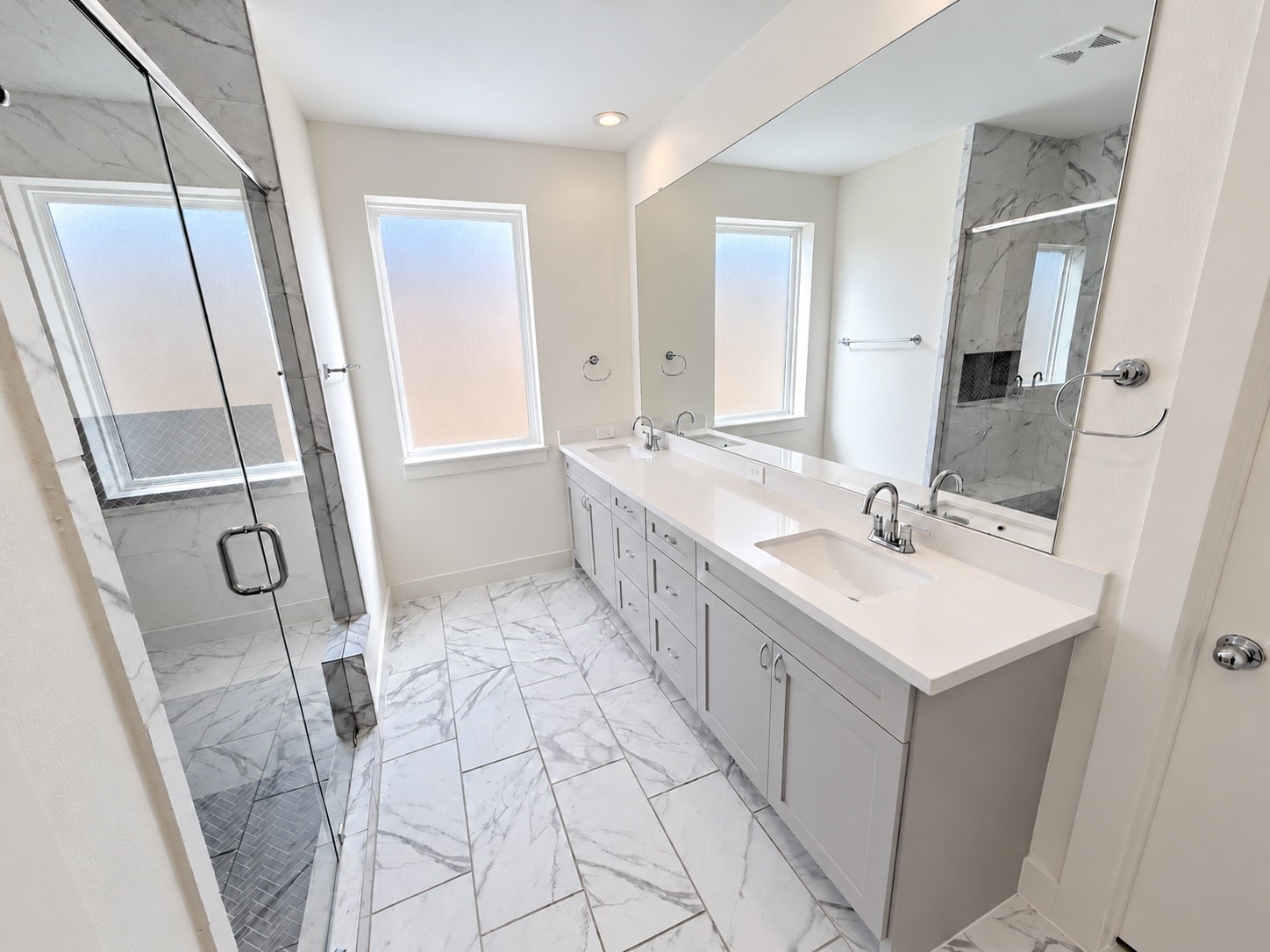 Elegant third-floor bathroom with dual sinks, a spacious vanity, and a glass-enclosed shower.