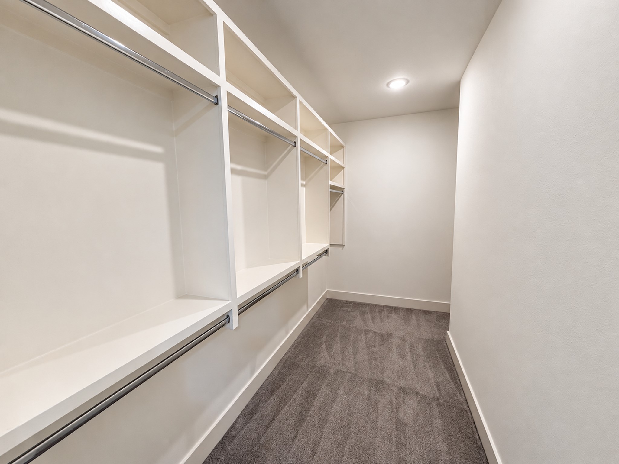 Spacious third-floor walk-in closet with built-in shelving and generous hanging space.