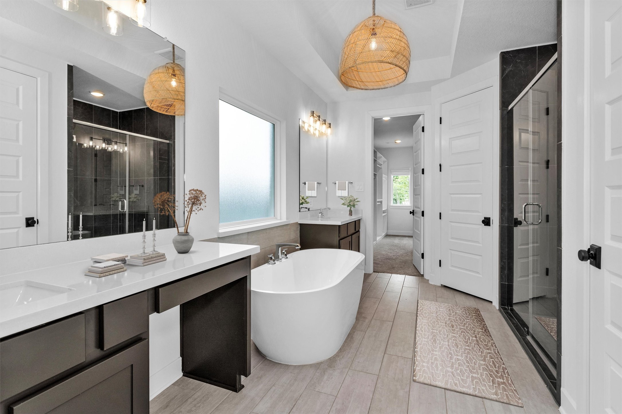 Luxurious primary bath featuring an upgraded soaking tub, separate walk-in shower, dual vanities, and an incredible closet w/built-inscreating a spa-like retreat designed for everyday indulgence.