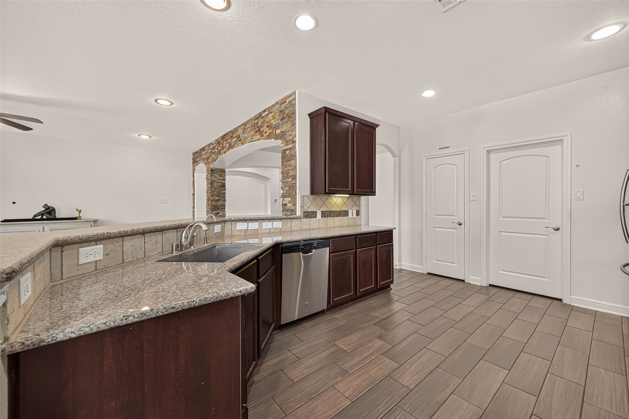 Another view of the spacious kitchen with rich wood cabinetry, sleek granite countertops, and modern stainless steel appliances.