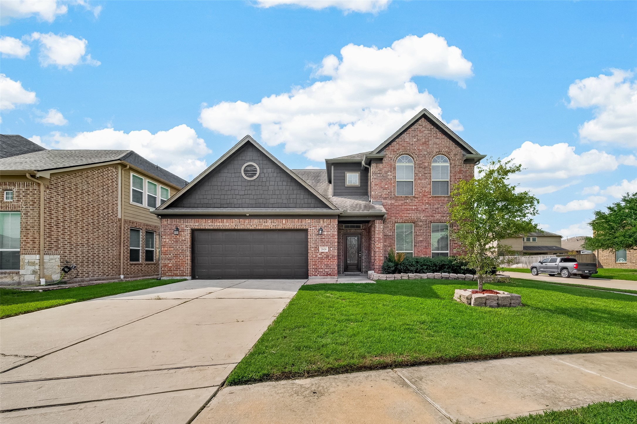 Charming two-story brick home featuring a spacious two-car garage, a well-maintained front yard, and excellent curb appeal