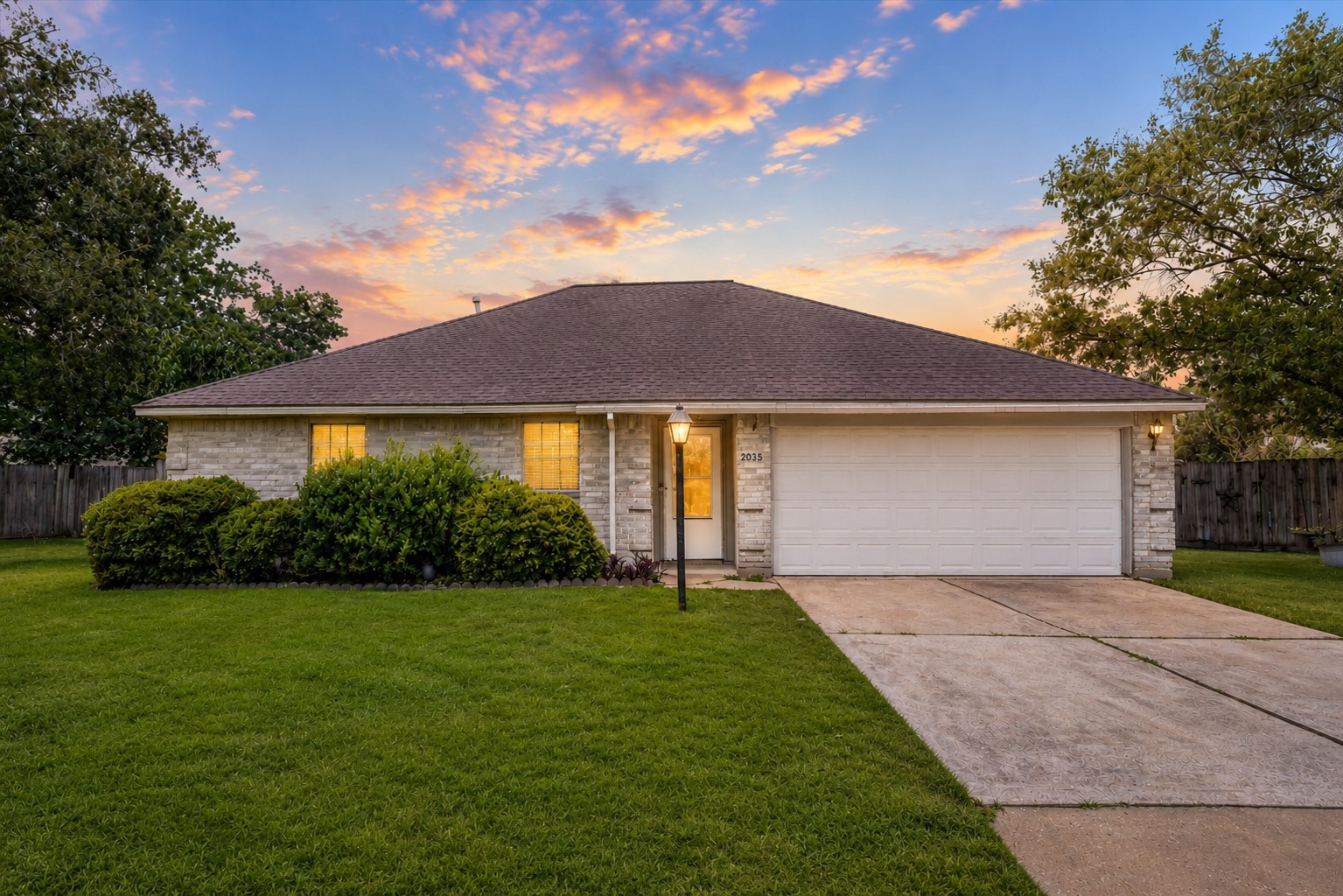 Welcome to 2035 Woodhue Dr. This well-maintained home in Imperial Oaks features a brick exterior, manicured lawn, mature landscaping, and attached two-car garage.