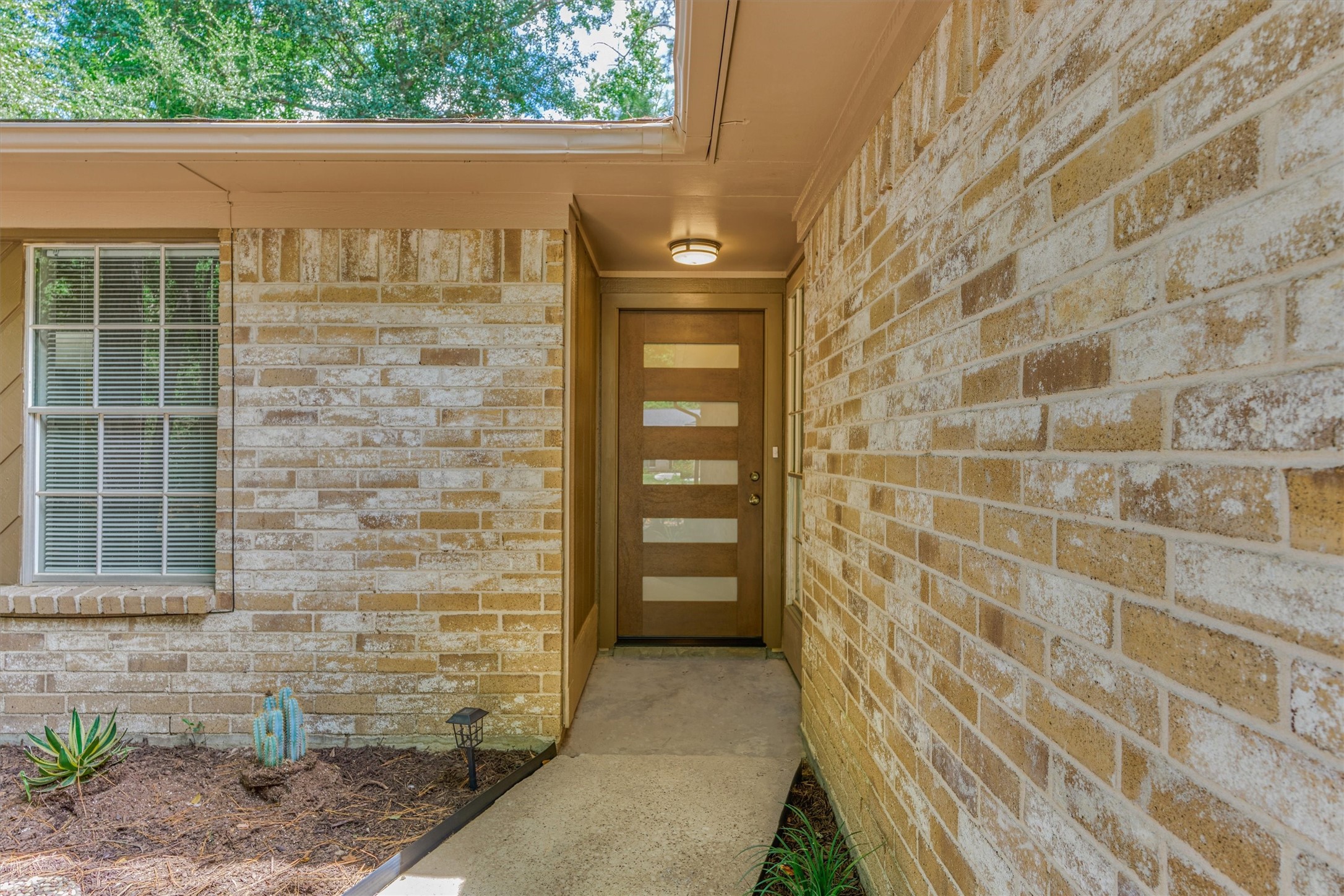 The new front door with privacy glass allows daylight to filter into the home.