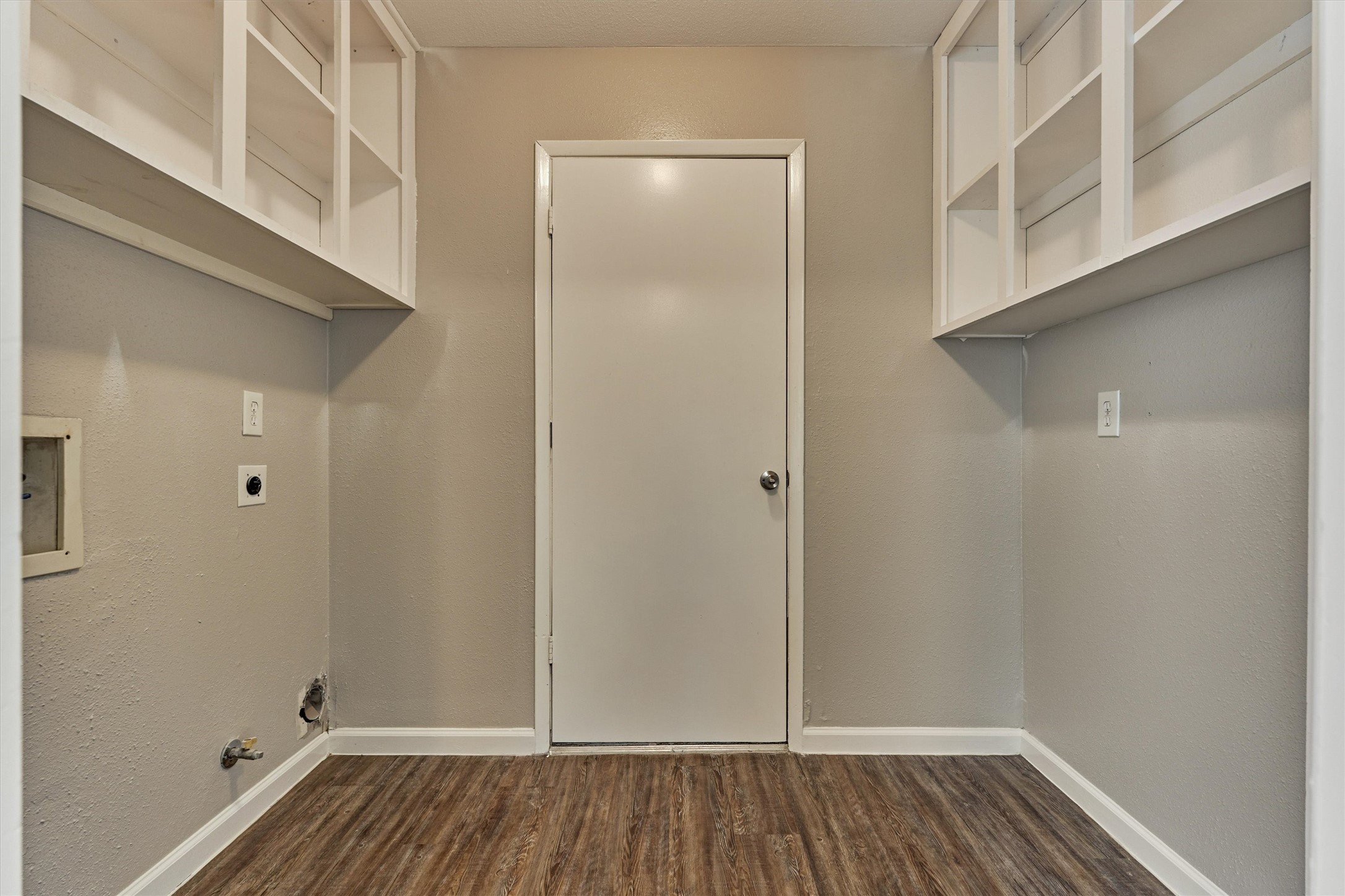 The indoor laundry room has built-in shelving for storage.