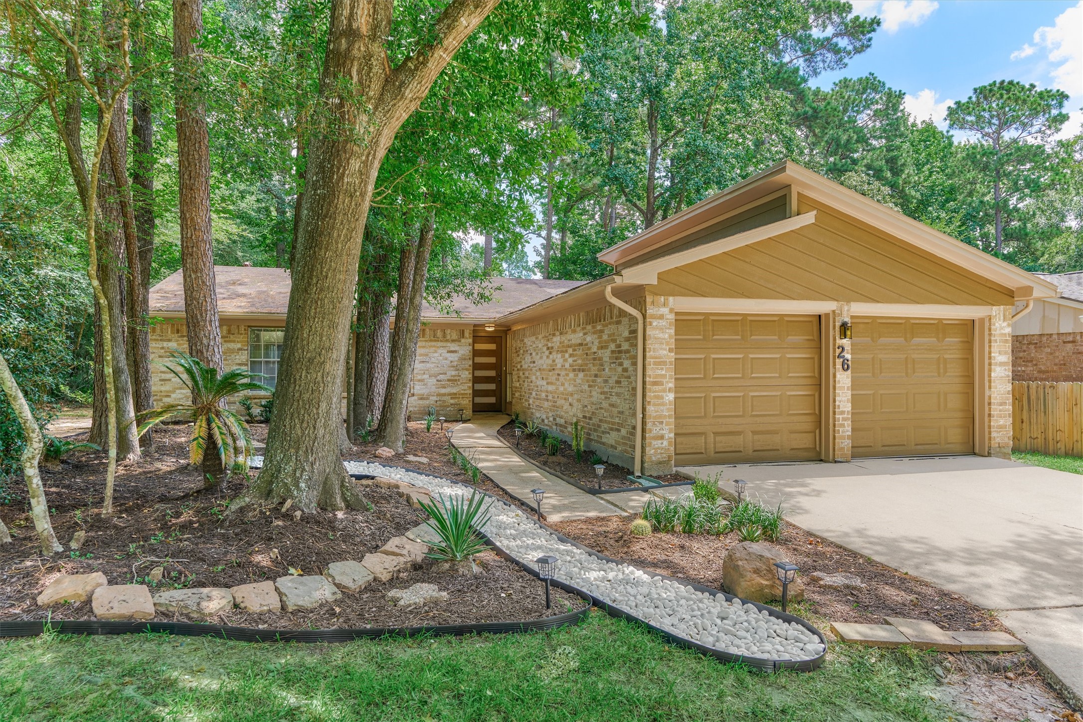 Low maintenance landscaping is achieved with a dry creek, mature trees and climate zone appropriate plantings.