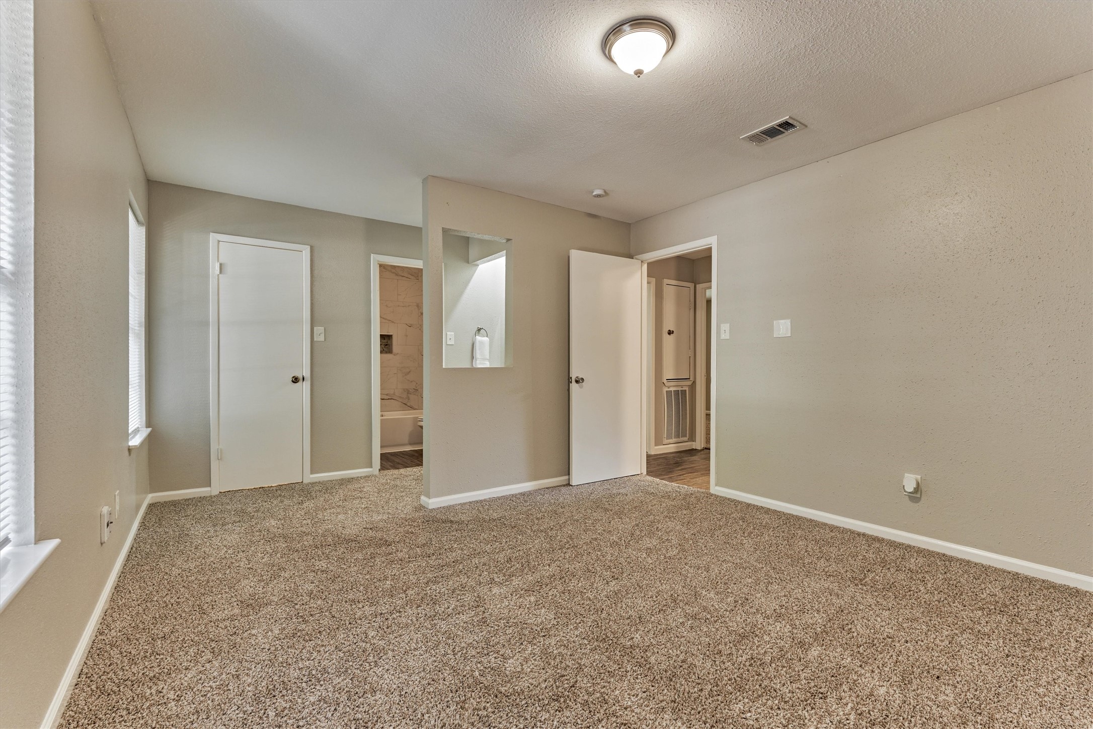 Another view of the primary bedroom which is spacious enough for a king size bed.