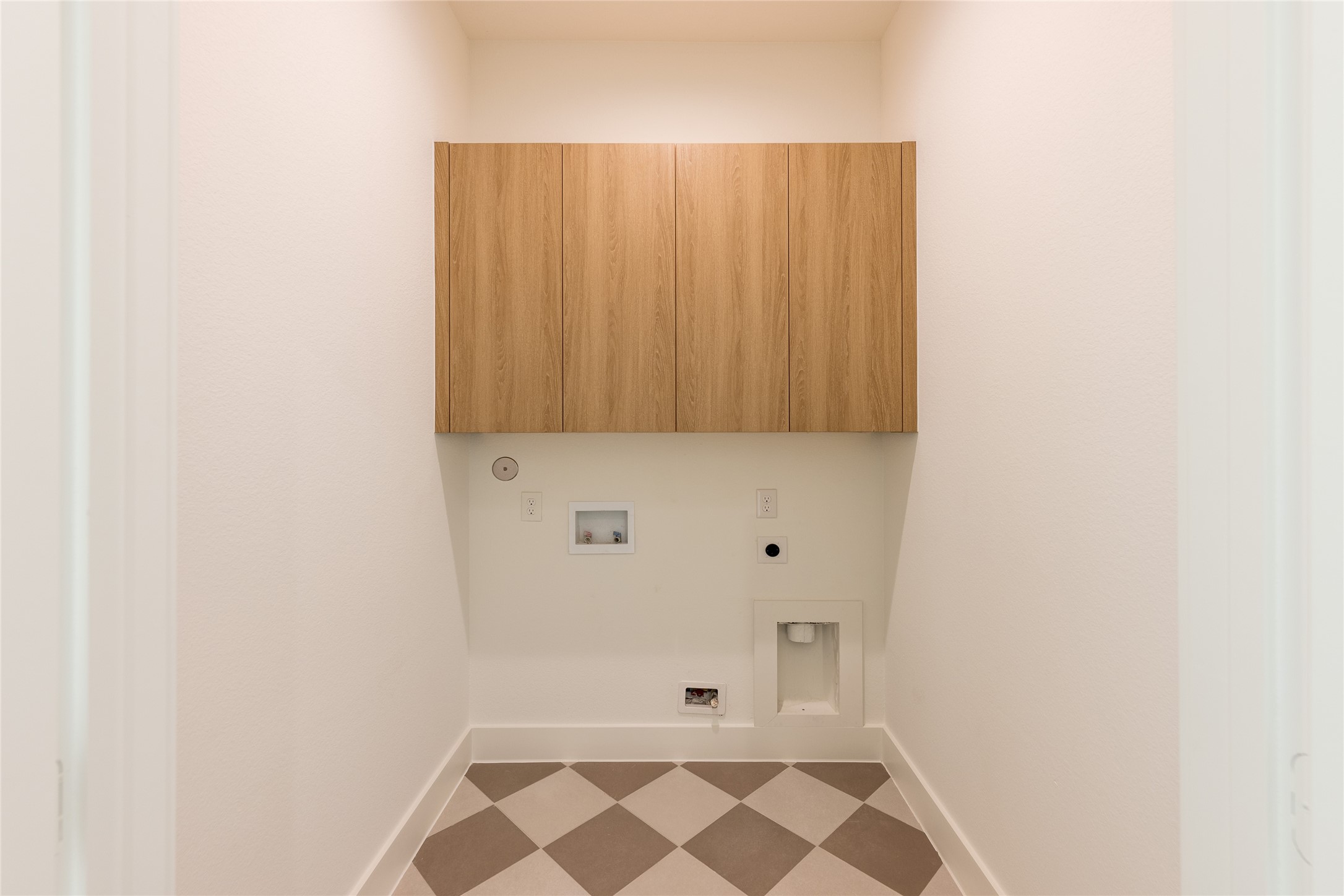 Utility are with modern checkered tiling and cabinets