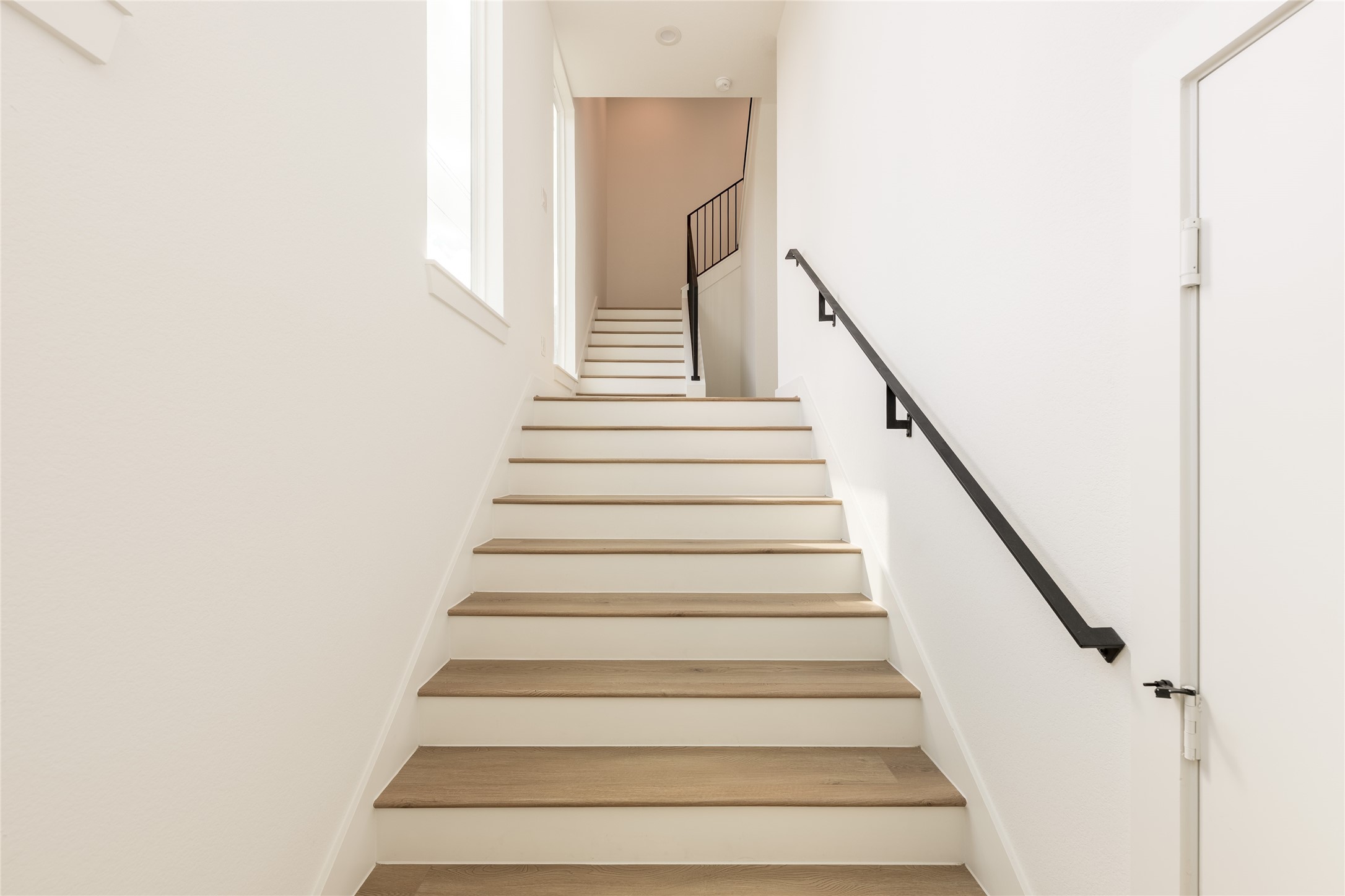 Inviting staircase with sleek handrails and wide modern wood steps, leading to the upper level filled with natural light. Inviting staircase with sleek handrails and wide modern wood steps, leading to the upper level filled with natural light.