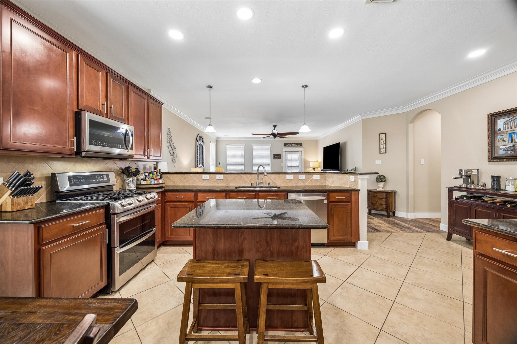 This spacious kitchen features granite countertops, a center island, rich wood cabinetry, and stainless steel appliances. Recessed lighting and generous counter space make everything from weeknight dinners to entertaining a breeze.