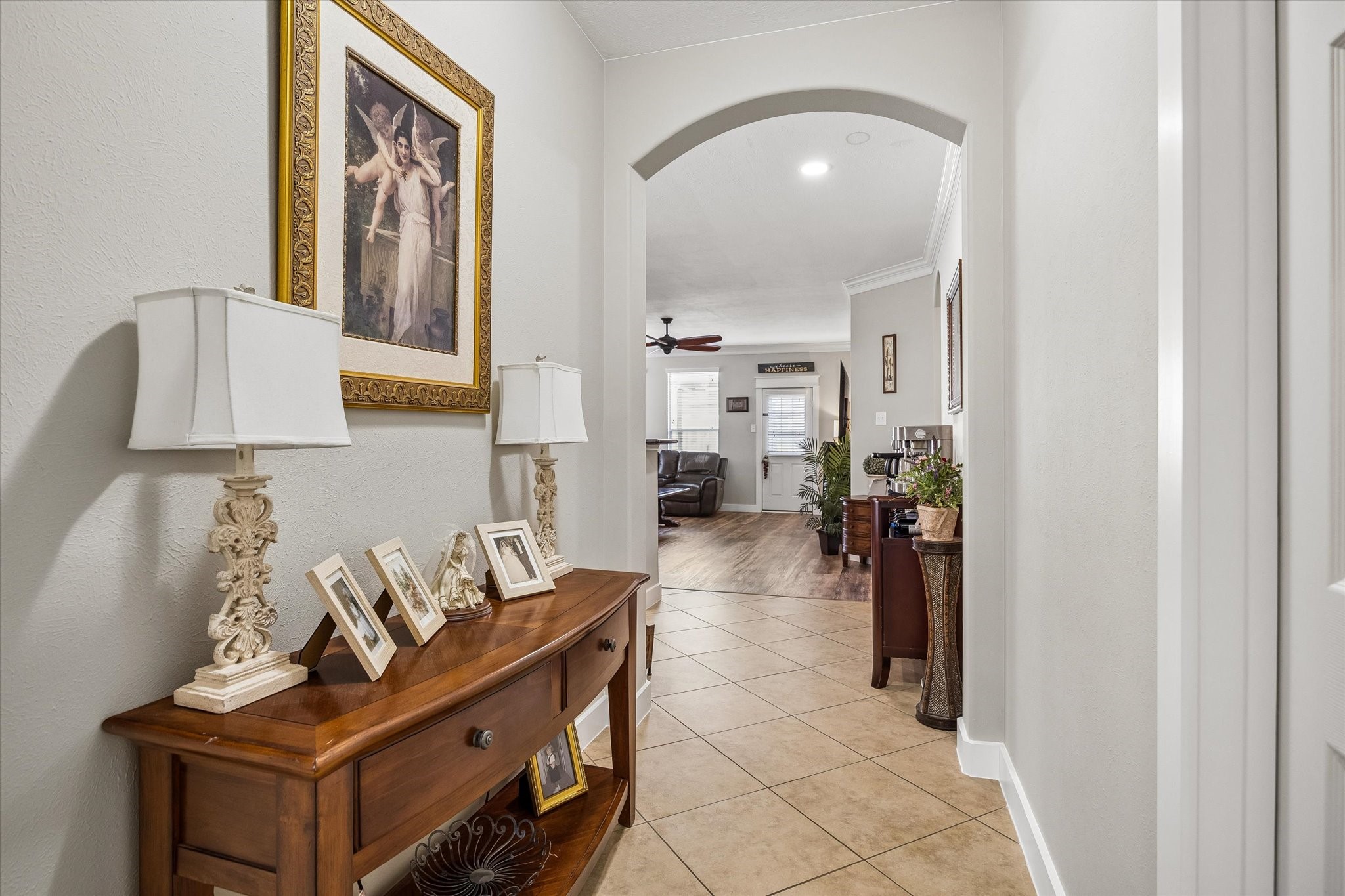 A welcoming entry hallway with arched openings and tile flooring creates an easy flow between the home's living spaces. Thoughtful architectural details add character throughout.