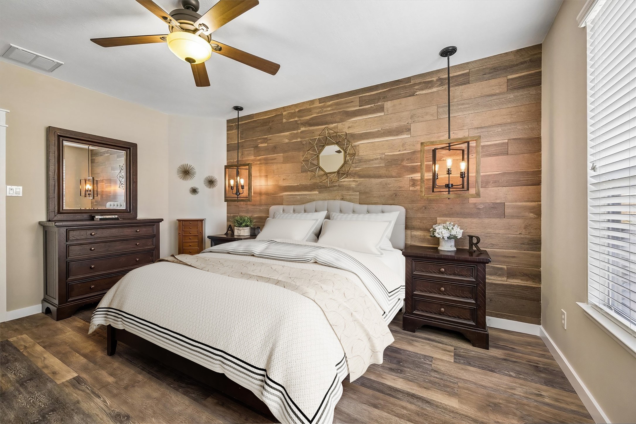 Another view of the primary bedroom highlights the rich wood detailing, natural light, and comfortable layout. It's a relaxing retreat with plenty of character and room to make your own.