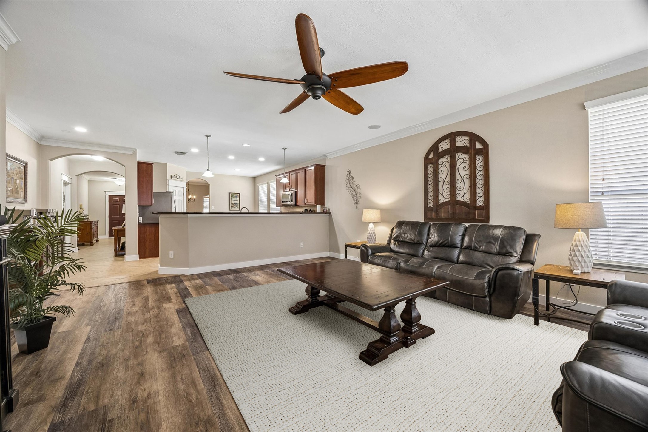 Another view of the family room highlights its generous proportions and open connection to the surrounding living areas. Natural light, neutral walls, and wood-look flooring create a welcoming space that's easy to make your own.