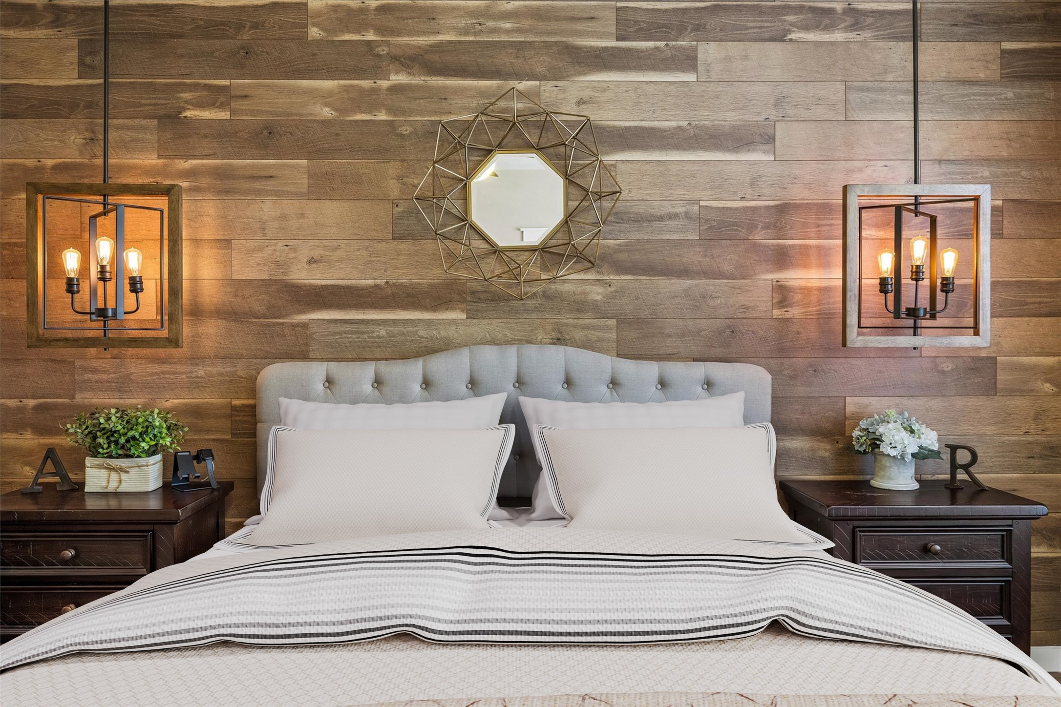 The primary bedroom's wood accent wall creates a beautiful focal point behind the bed, complemented by pendant lighting on either side. A thoughtful design detail that gives the space a cozy, inviting feel.