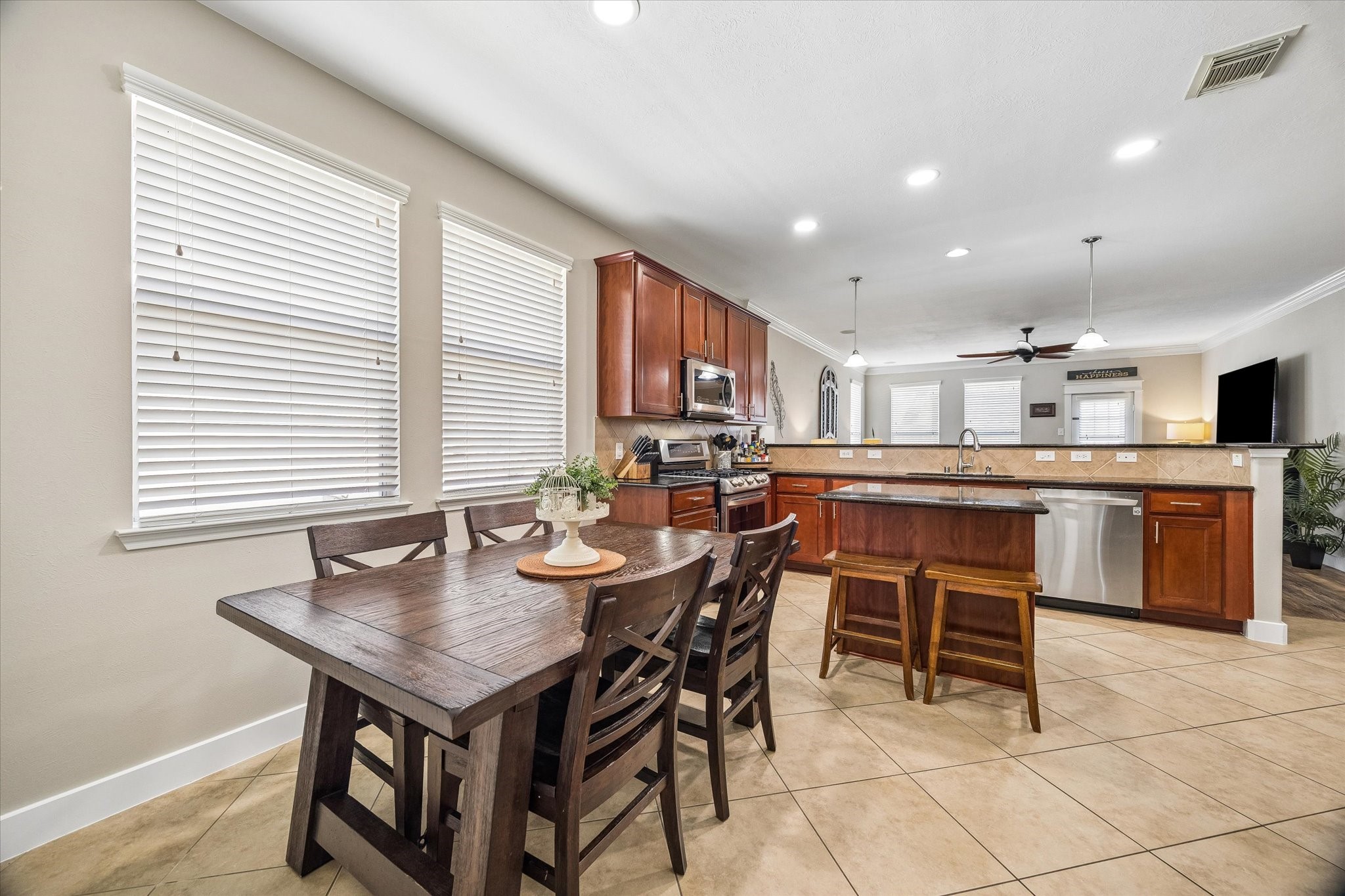 The island kitchen offers granite countertops, rich wood cabinetry, and plenty of space for preparing meals or gathering with family. A nearby breakfast area brings in natural light and makes everyday dining easy.