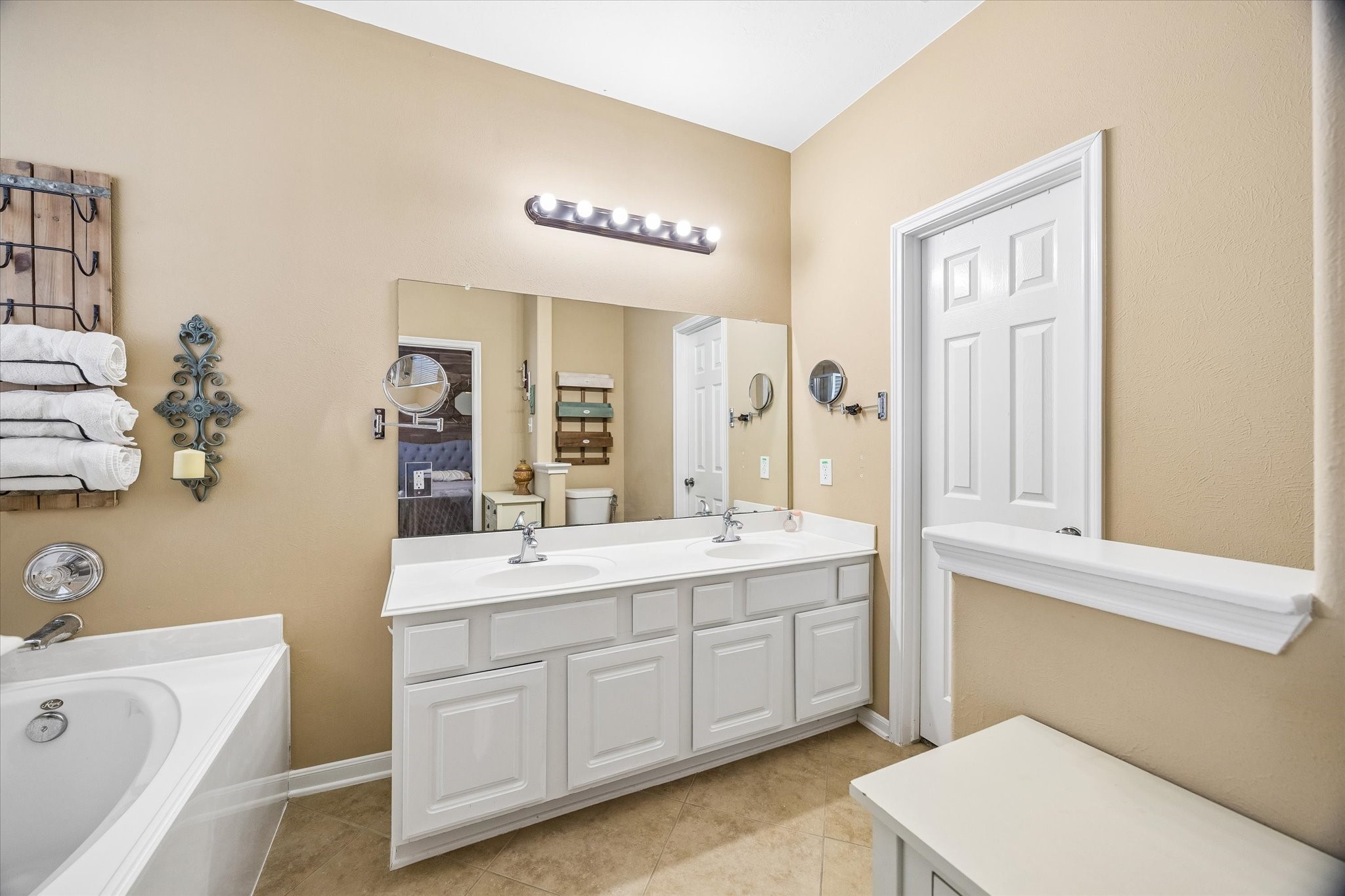 The primary bathroom features a spacious vanity with dual sinks, a soaking tub, and a separate shower. Natural light and neutral finishes create a comfortable space to start and end the day.