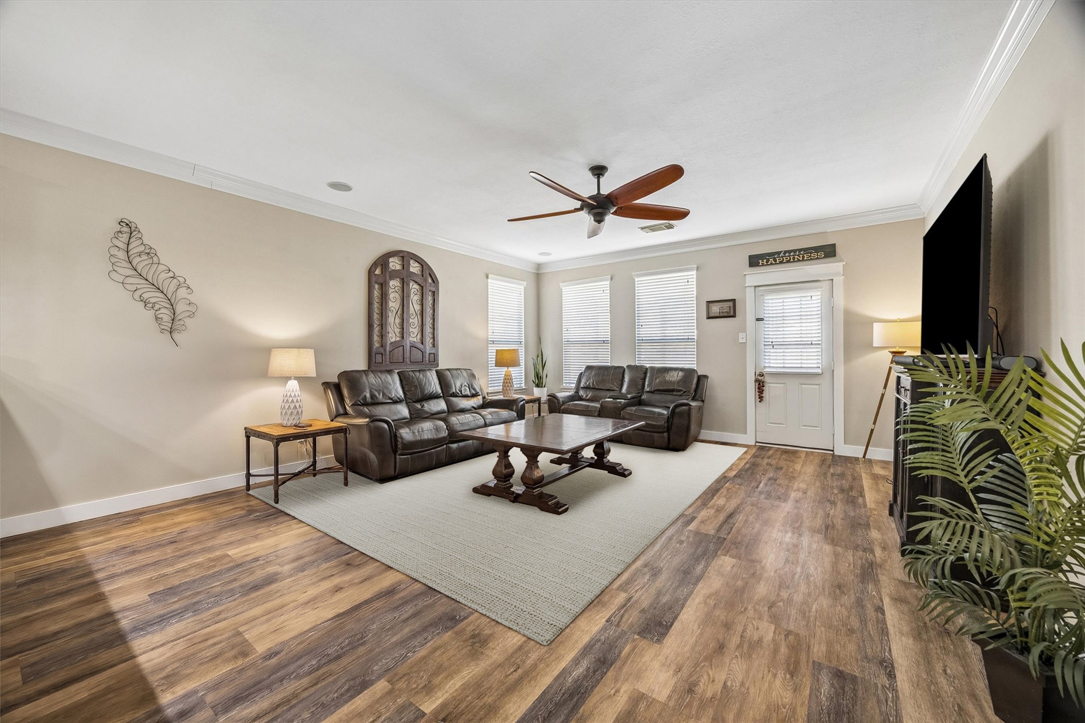 The family room offers a comfortable place to unwind, with beautiful wood-look flooring, a ceiling fan, and plenty of natural light. There's room for generous seating without sacrificing the open, airy feel.