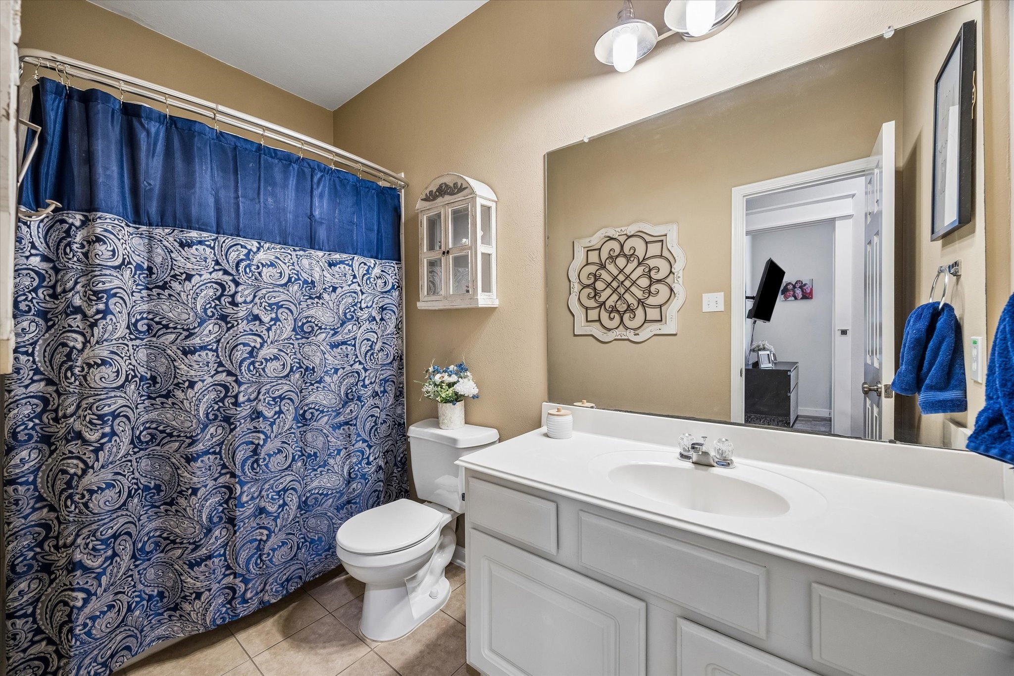 The secondary bathroom features a spacious vanity, tub and shower combination, and neutral finishes. Conveniently located for guests and secondary bedrooms.