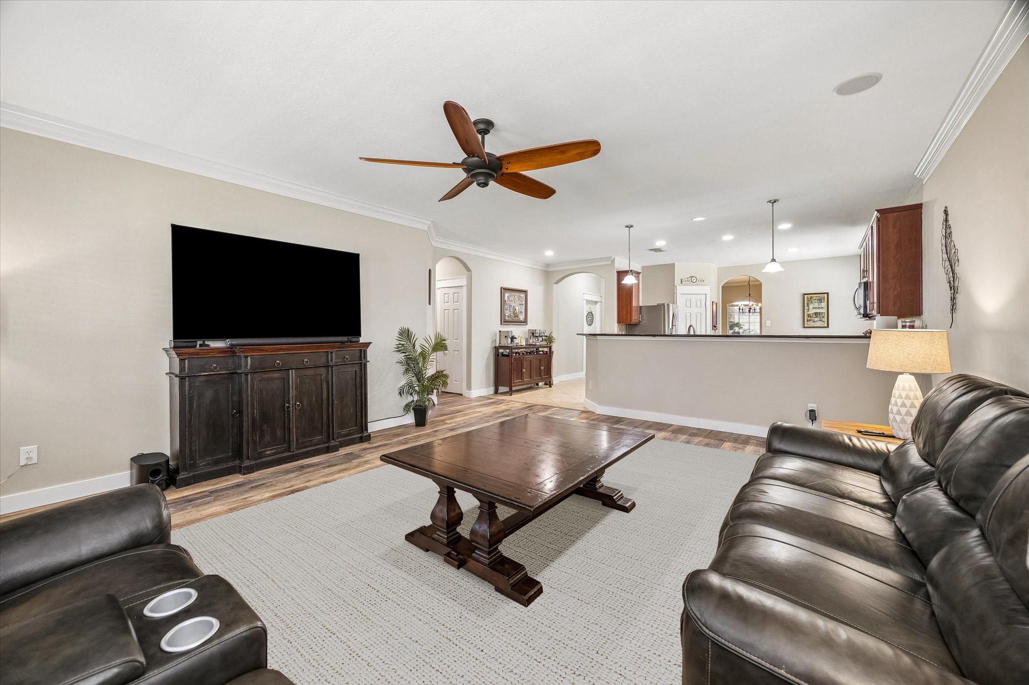 The family room offers plenty of space to relax or entertain, with warm wood-look flooring and a ceiling fan. Its open layout creates a comfortable setting for movie nights, family gatherings, or simply unwinding at home.