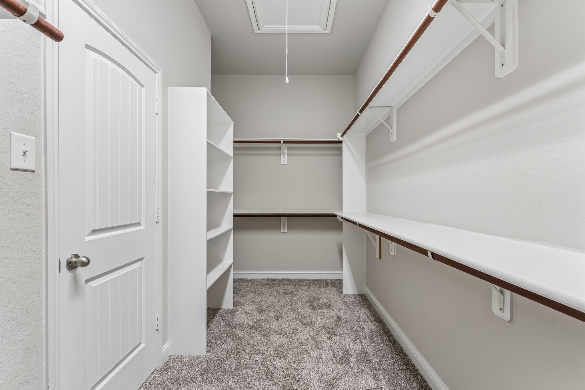 Spacious walk-in closet with ample shelving and hanging space, perfect for organized storage.