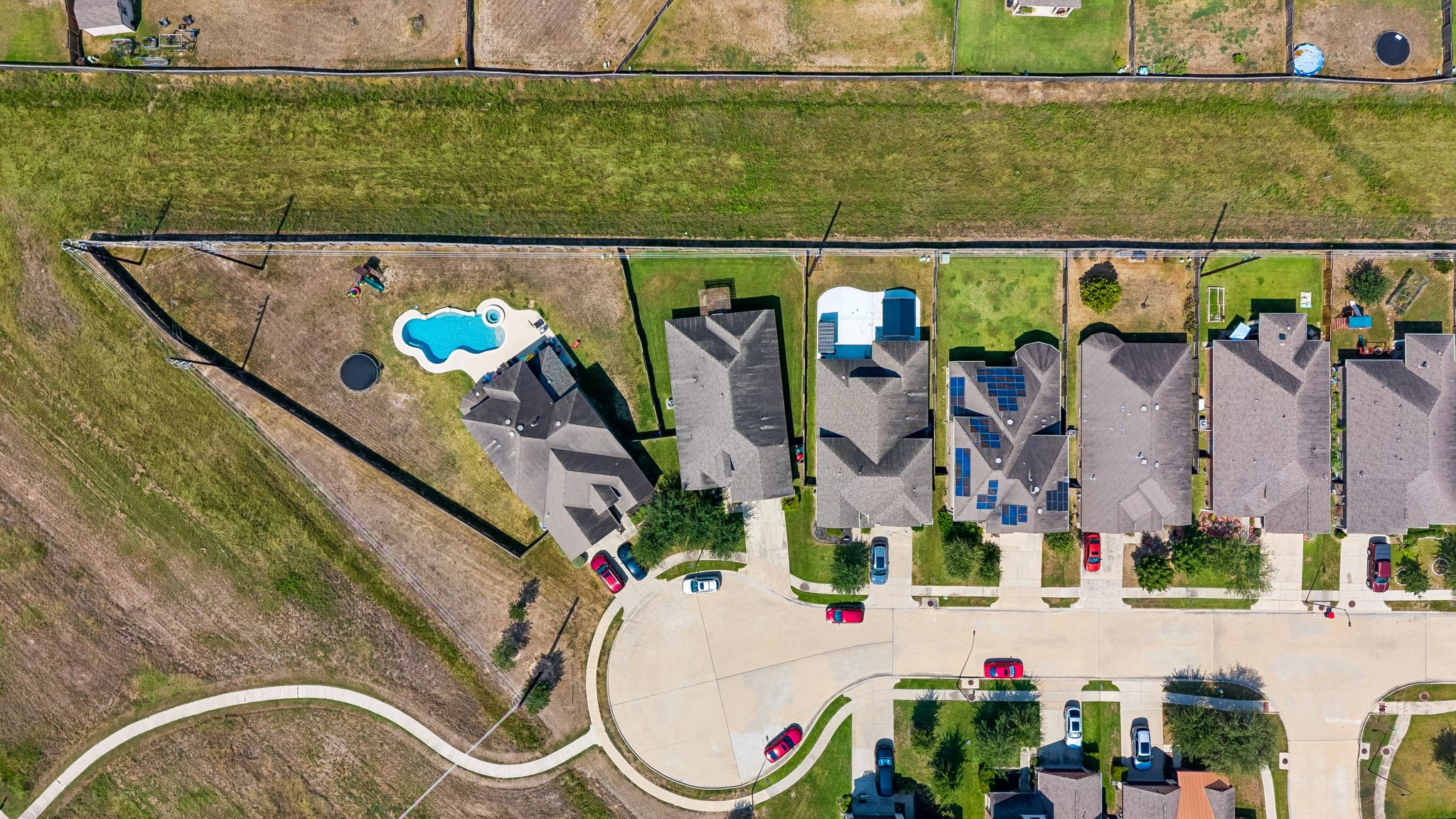 Aerial view of a charming cul-de-sac neighborhood featuring spacious backyards, against a lush greenbelt for added privacy of no back neighbors on a private street.