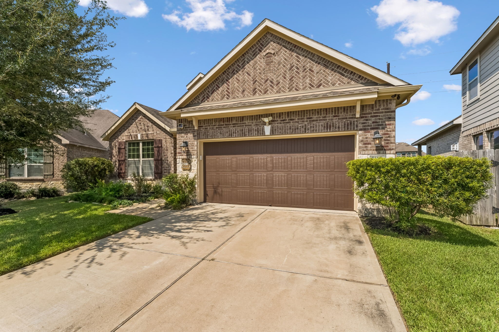 Charming brick home with a well-maintained front yard, featuring a spacious two-car garage and inviting curb appeal.